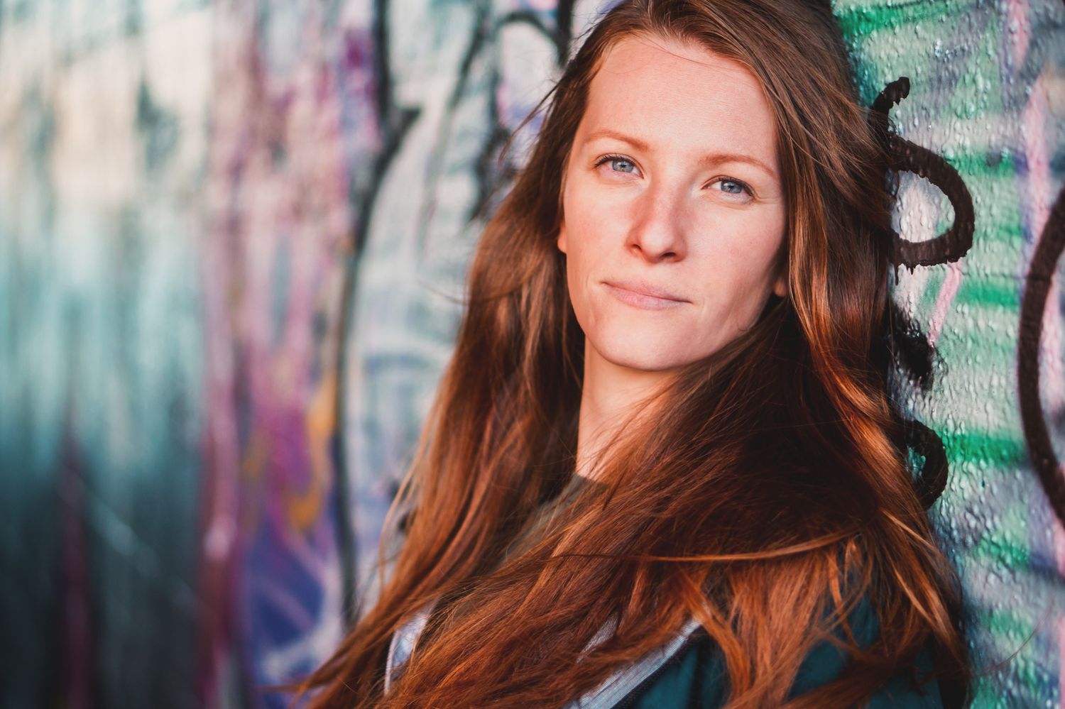 Portrait series showing person with long hair against colorful graffiti background.