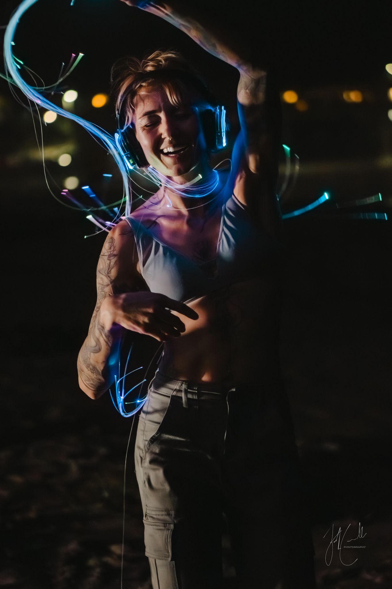 Light painting photography creates glowing blue streaks against a dark background in a dynamic nighttime scene.