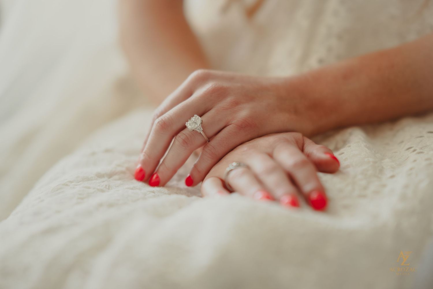 Close-up of hands touching delicate white lace fabric with soft lighting.