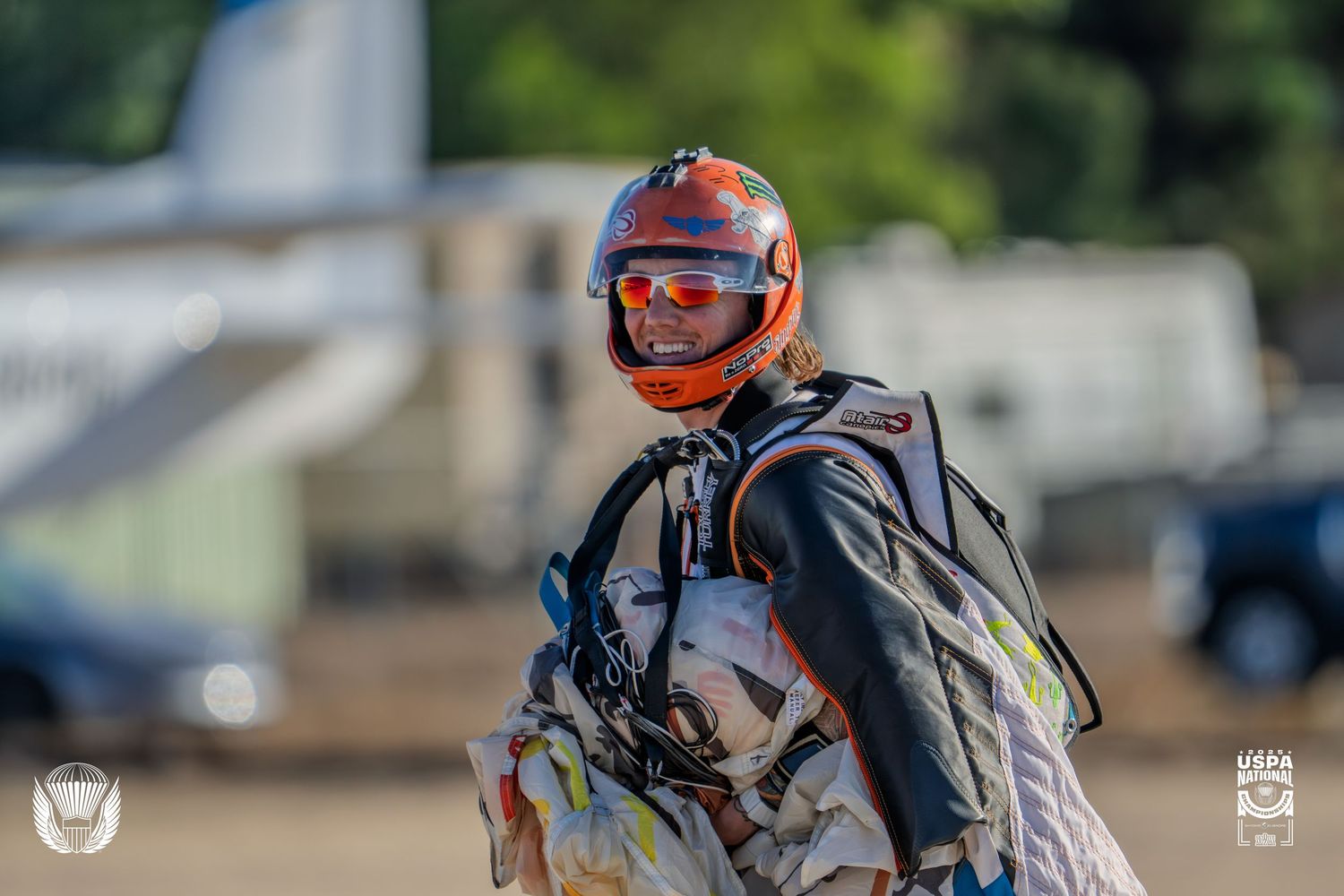 Motorcyclist racing across track with dramatic motion blur effect.