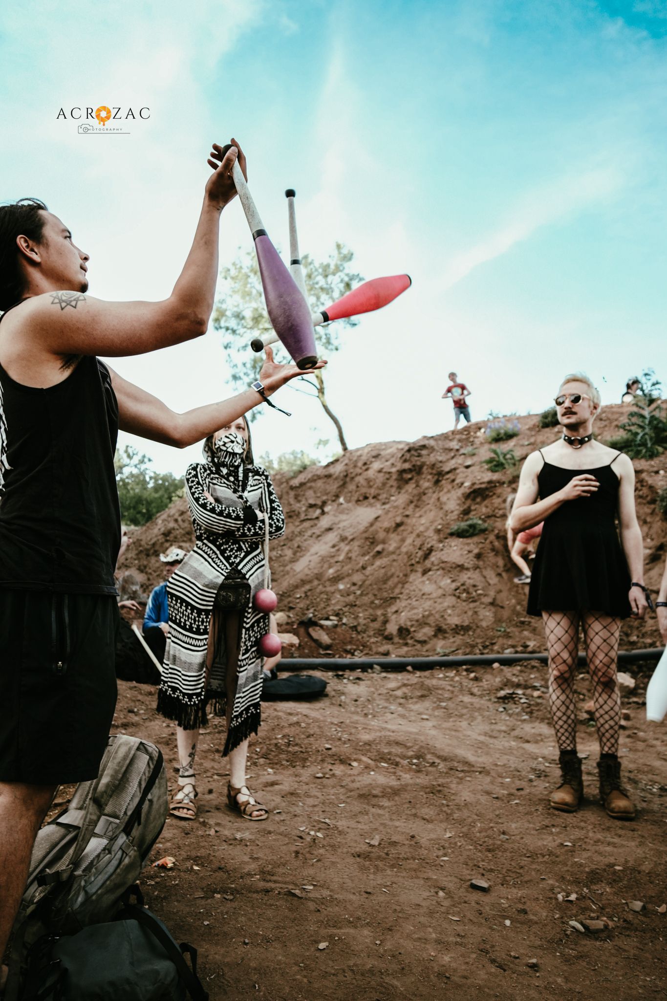 People dancing and celebrating at a muddy outdoor festival ground.