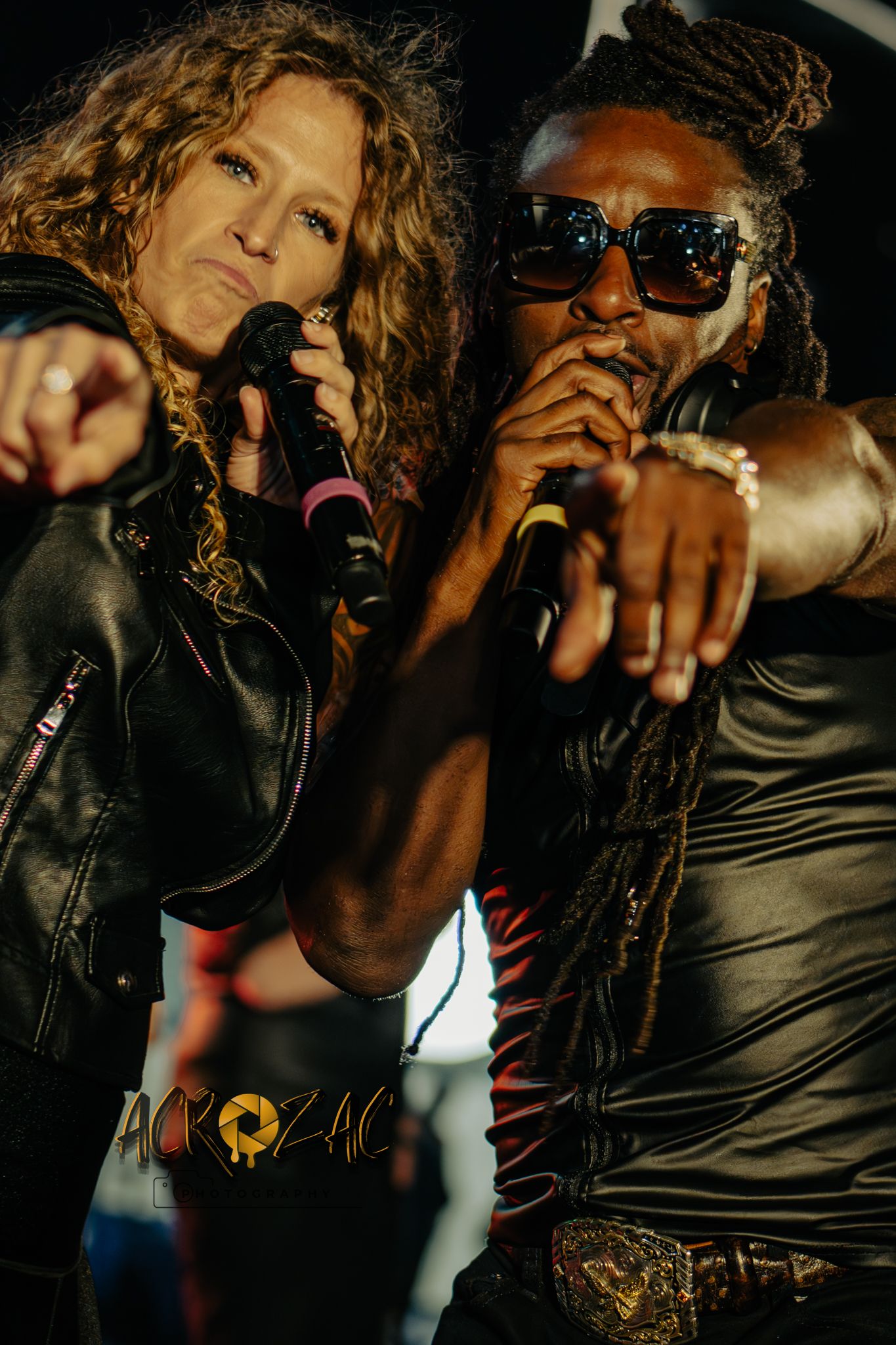 Dramatic performance photos in dark lighting with performers in black leather outfits.