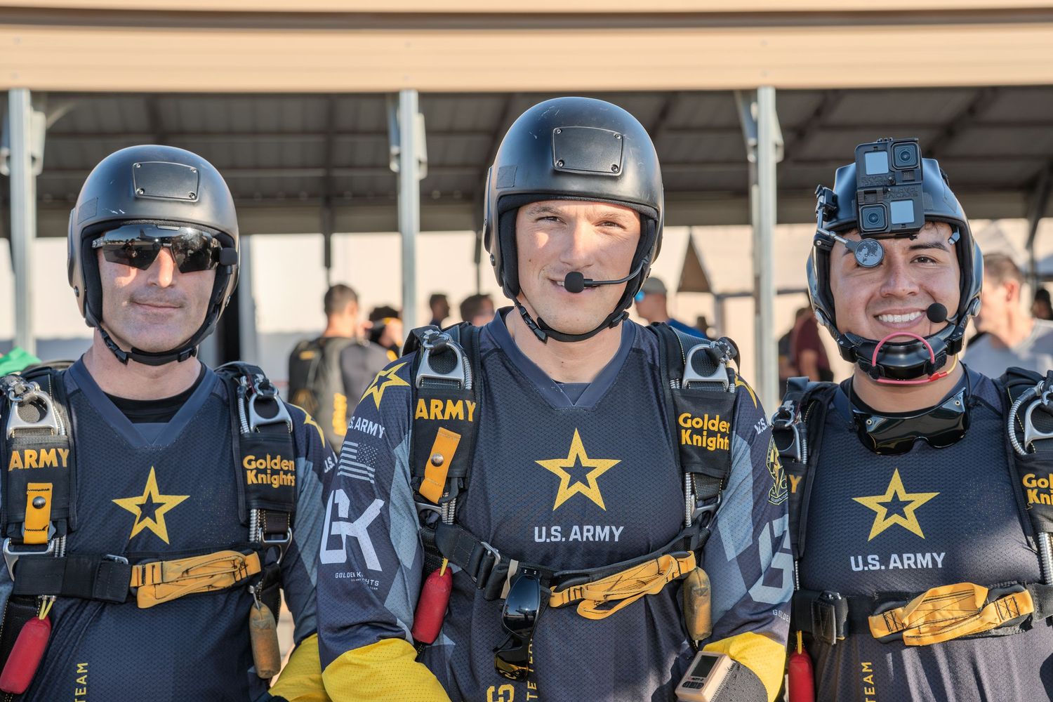 Row of military skydivers wearing helmets and gear with Army insignia.
