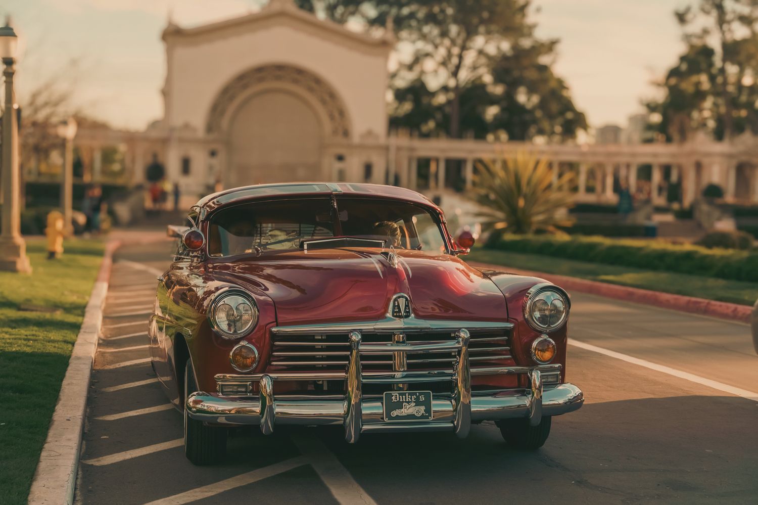 Row of classic vintage cars parked in front of historic architecture.
