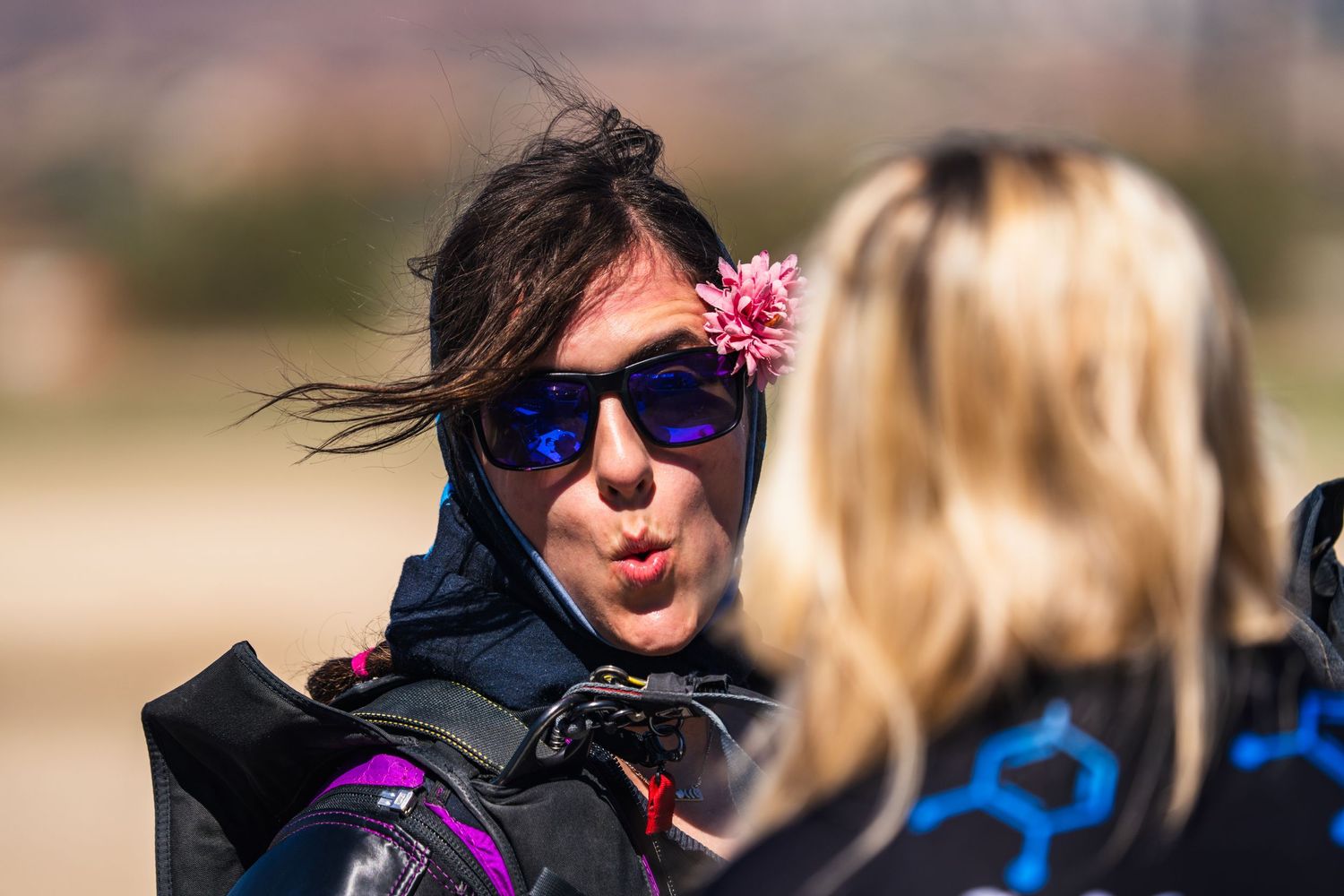 People enjoying outdoor activities with sunglasses against a blurred natural background.