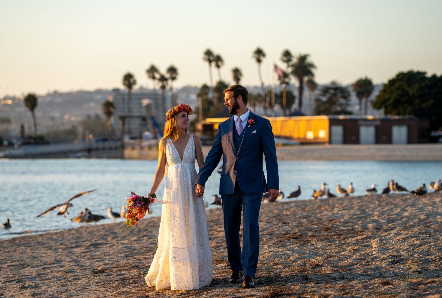 Romantic beach wedding photo with palm trees and golden sunset light.