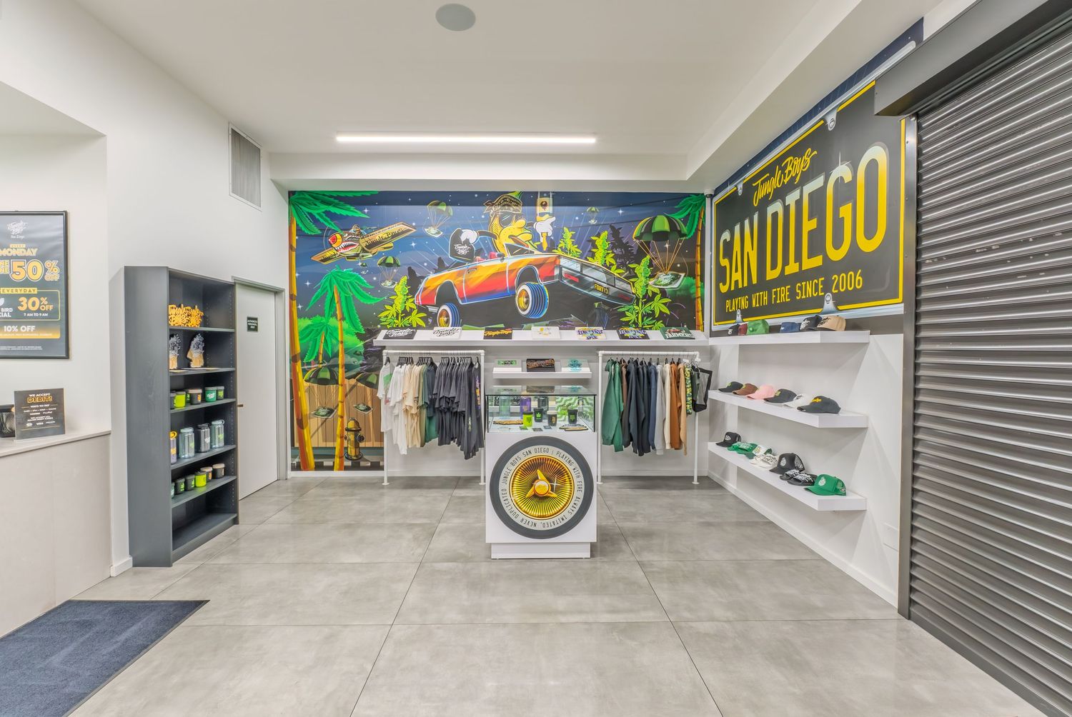San Diego themed retail store interior with colorful mural, clothing racks, display shelves, and merchandise on gray tile floors.