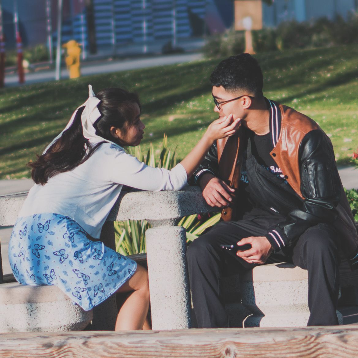 Romantic couple sequence showing intimate moments on a wooden bench outdoors.