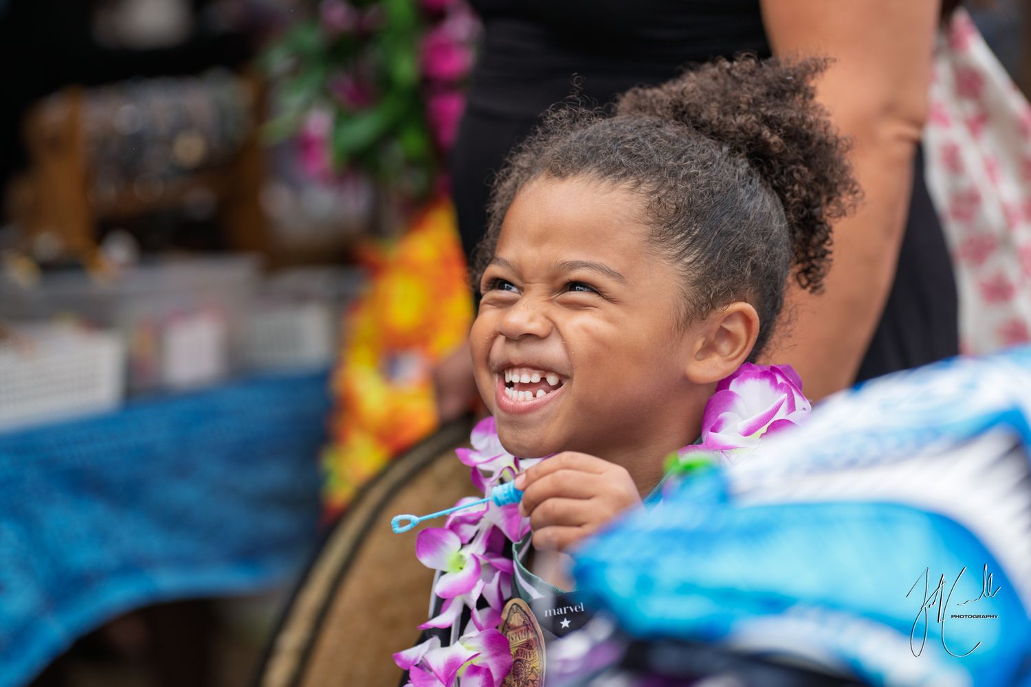 Joy and laughter at a festive outdoor celebration with colorful leis.