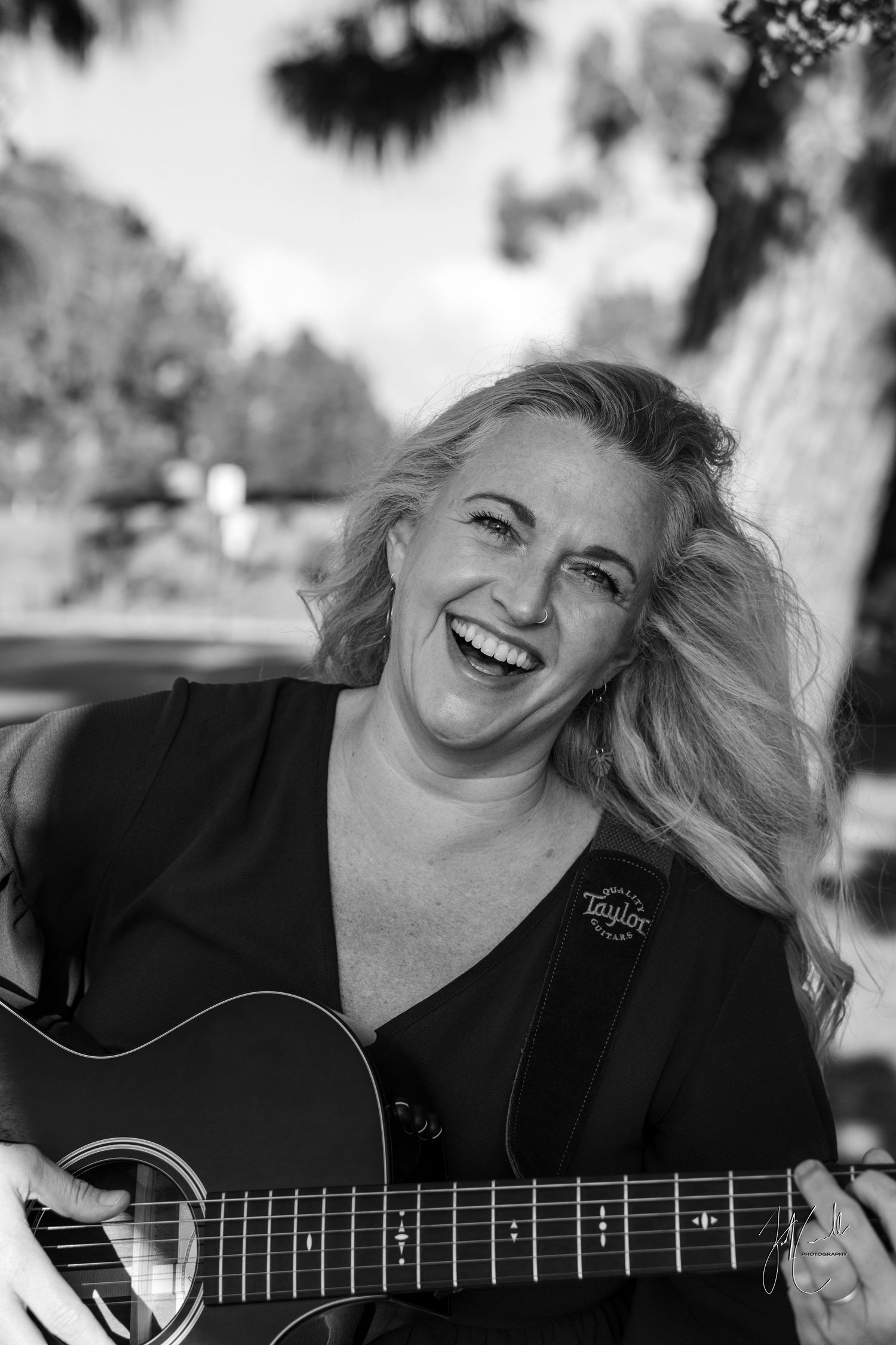 Musician playing acoustic guitar in black and white portrait series.