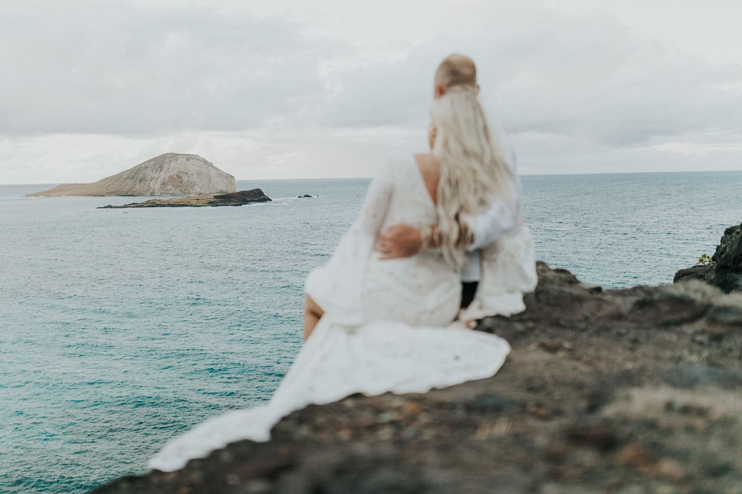 Breathtaking Bridal Portrait on a dramatic rocky coast overlooking the sea, showcasing a luxury wedding dress for a destination elopement.