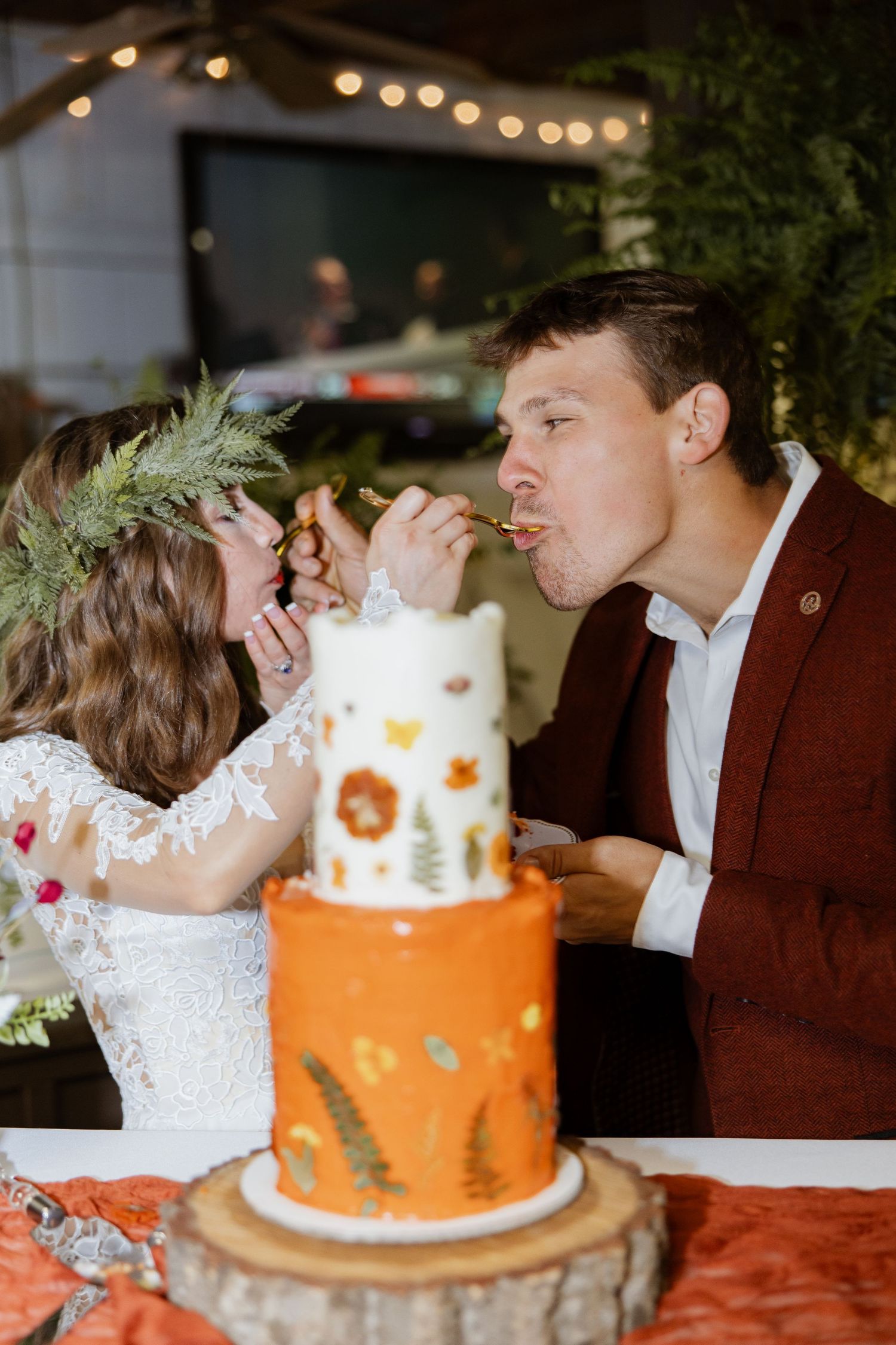 Candid, fine art wedding photography moment of the couple feeding each other their wedding cake. Documentary storytelling.