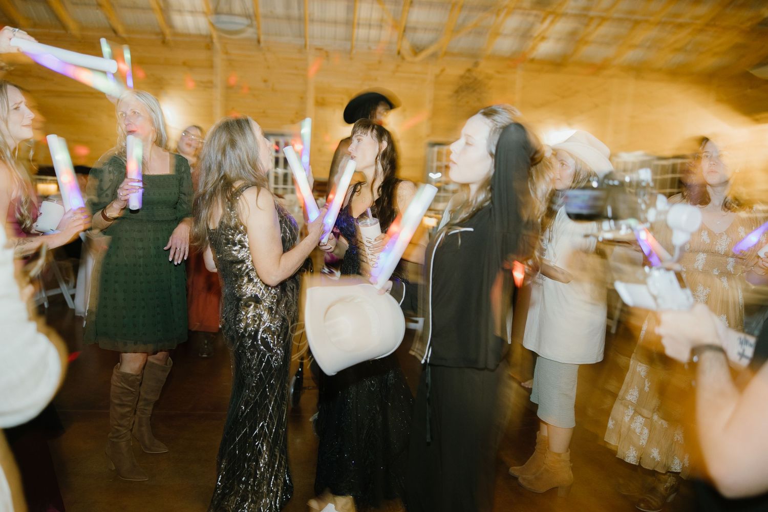 High-energy wedding reception party photo with motion blur, capturing guests dancing. Ideal for a fun, story-driven wedding