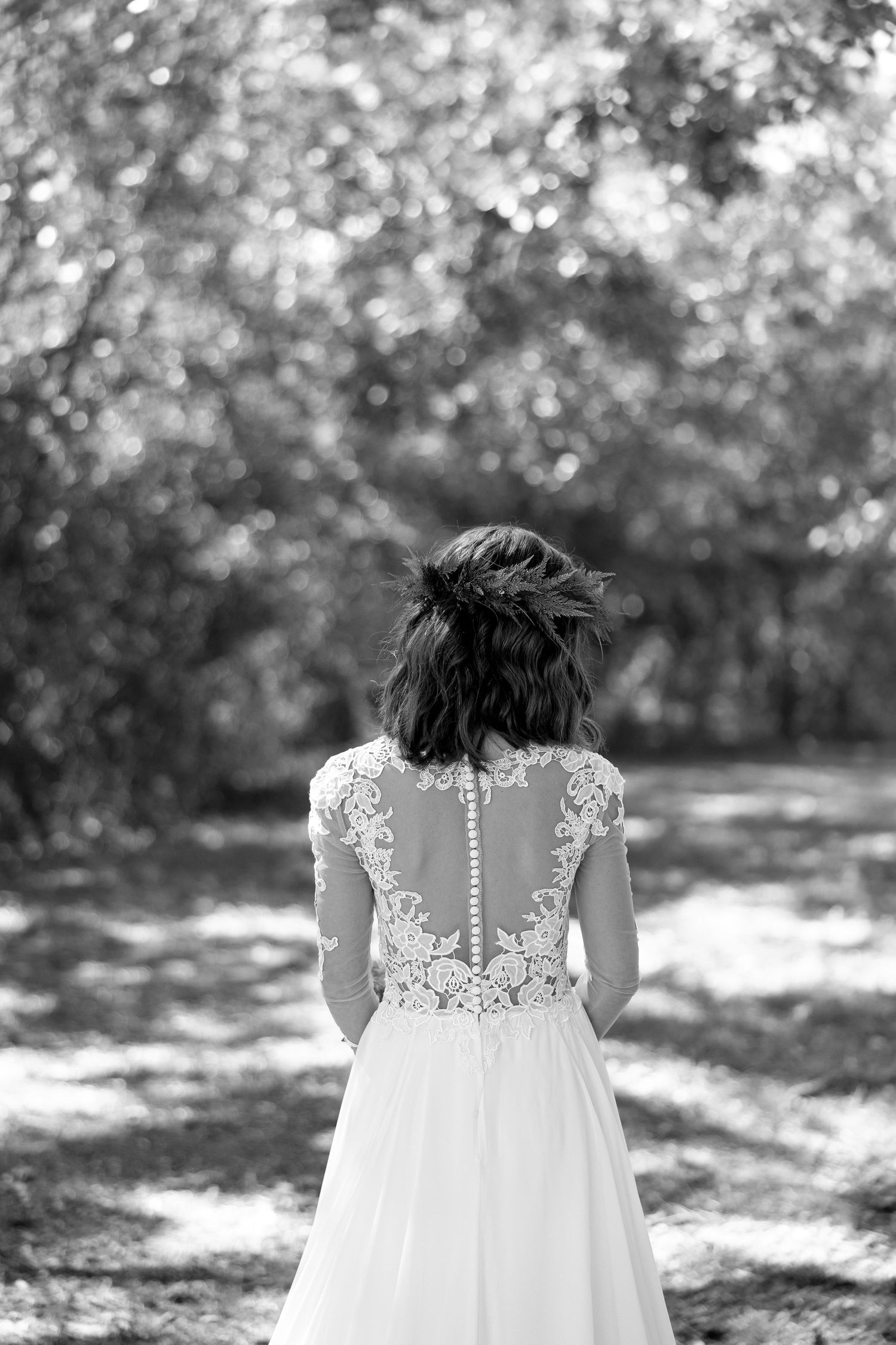 Emotional Black and White Documentary detail shot of the back of the bride's lace dress and detailed hairstyle.