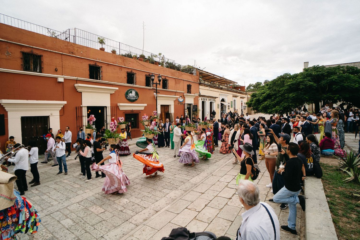 Panoramic view of a festive gathering on colonial Mexican architecture with stone pathways.