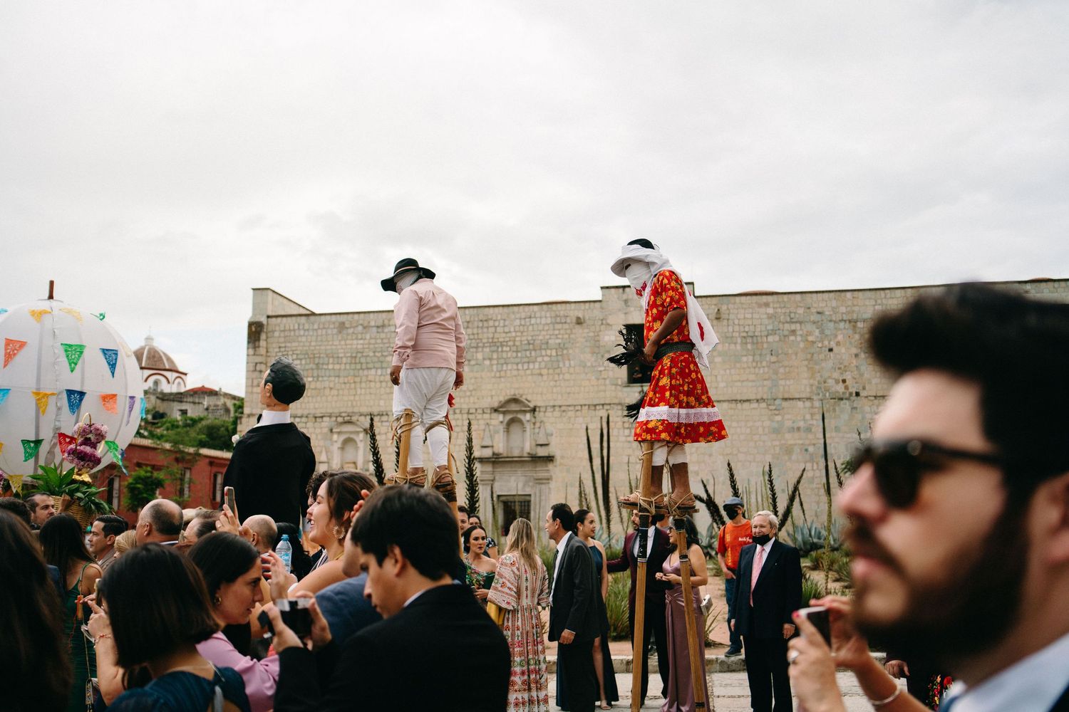 Guests celebrate at outdoor wedding reception with bunting decorations.