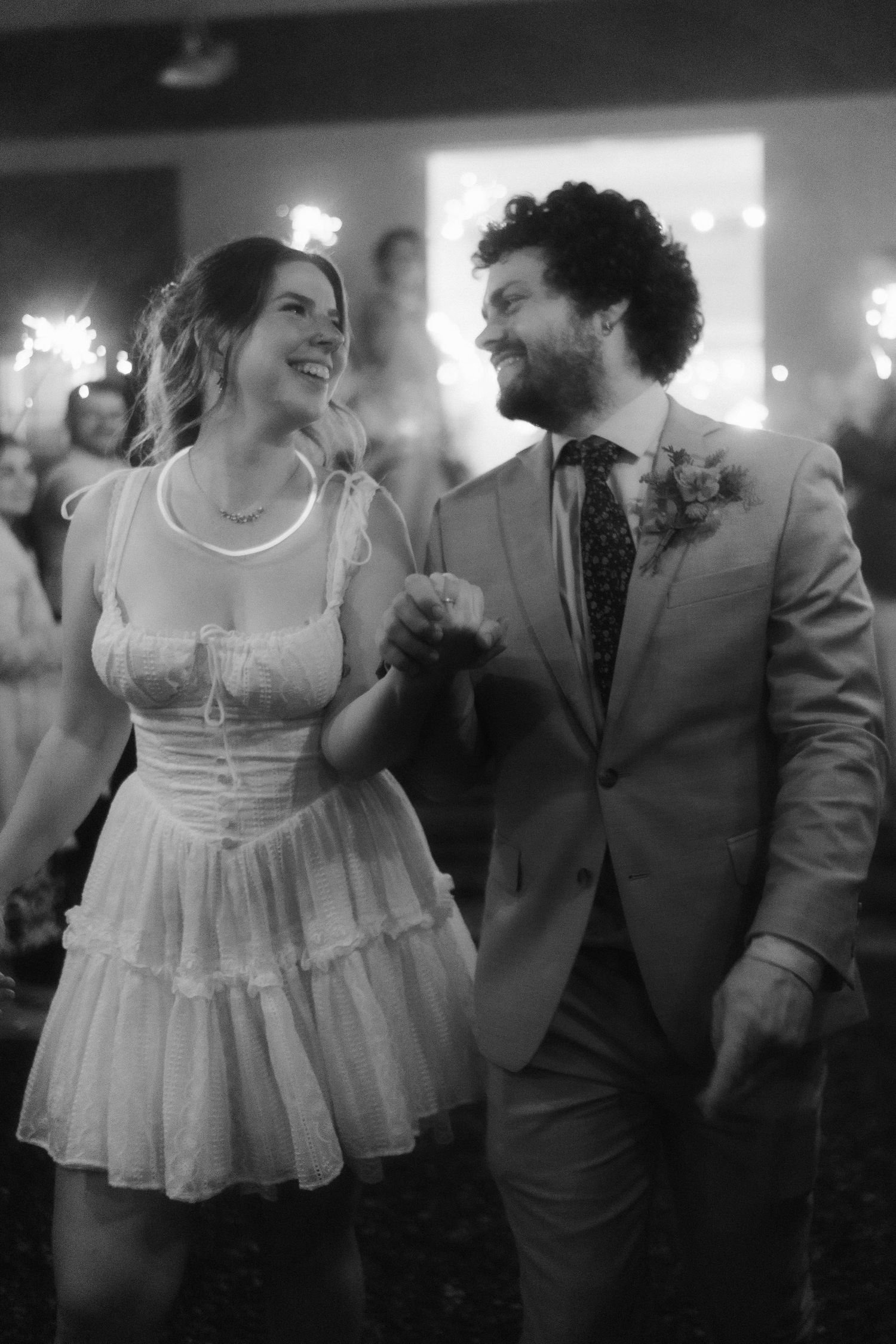 A couple dancing together at a wedding reception in black and white.