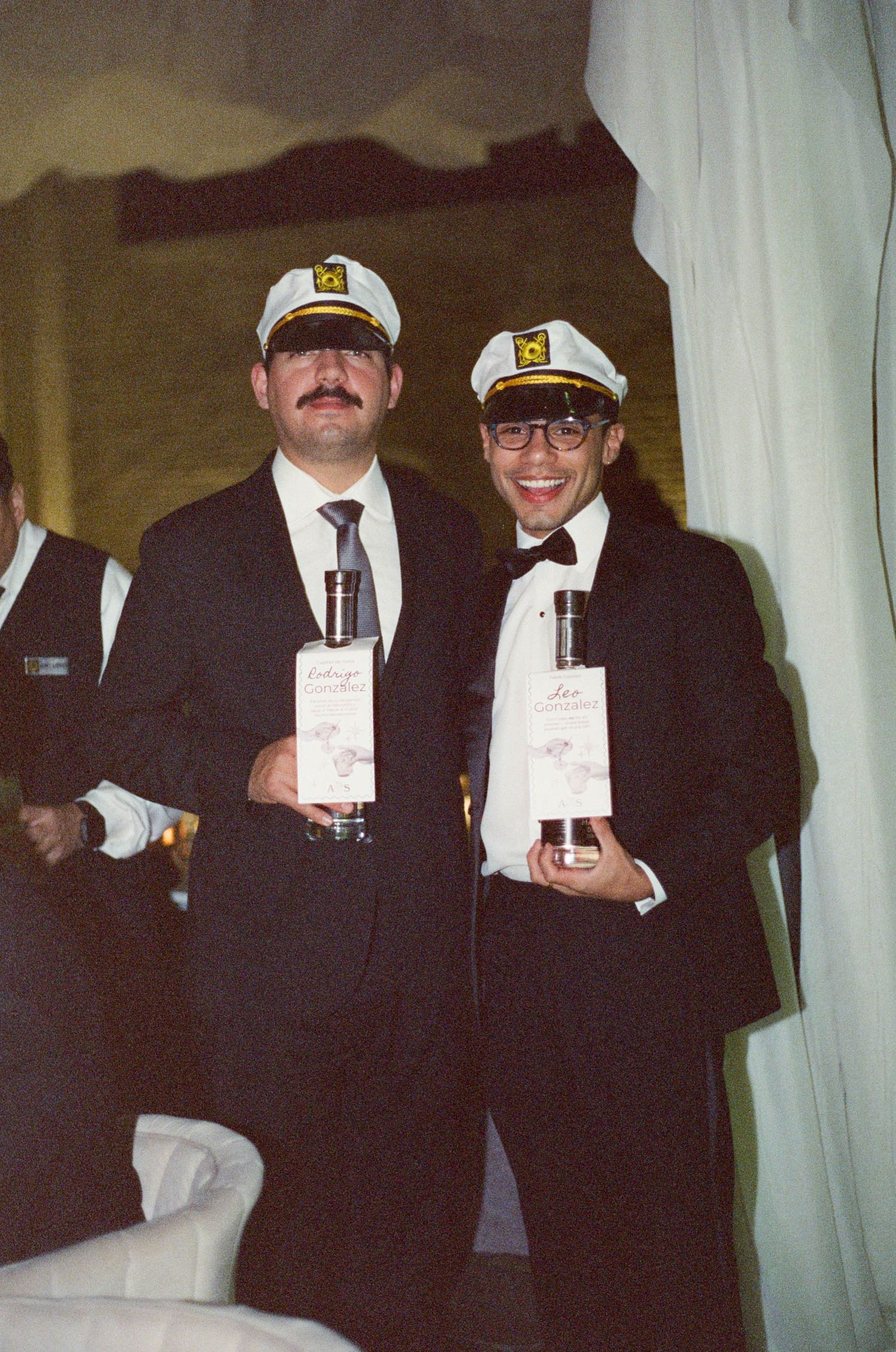Guests wearing nautical captain hats pose together at a themed party.