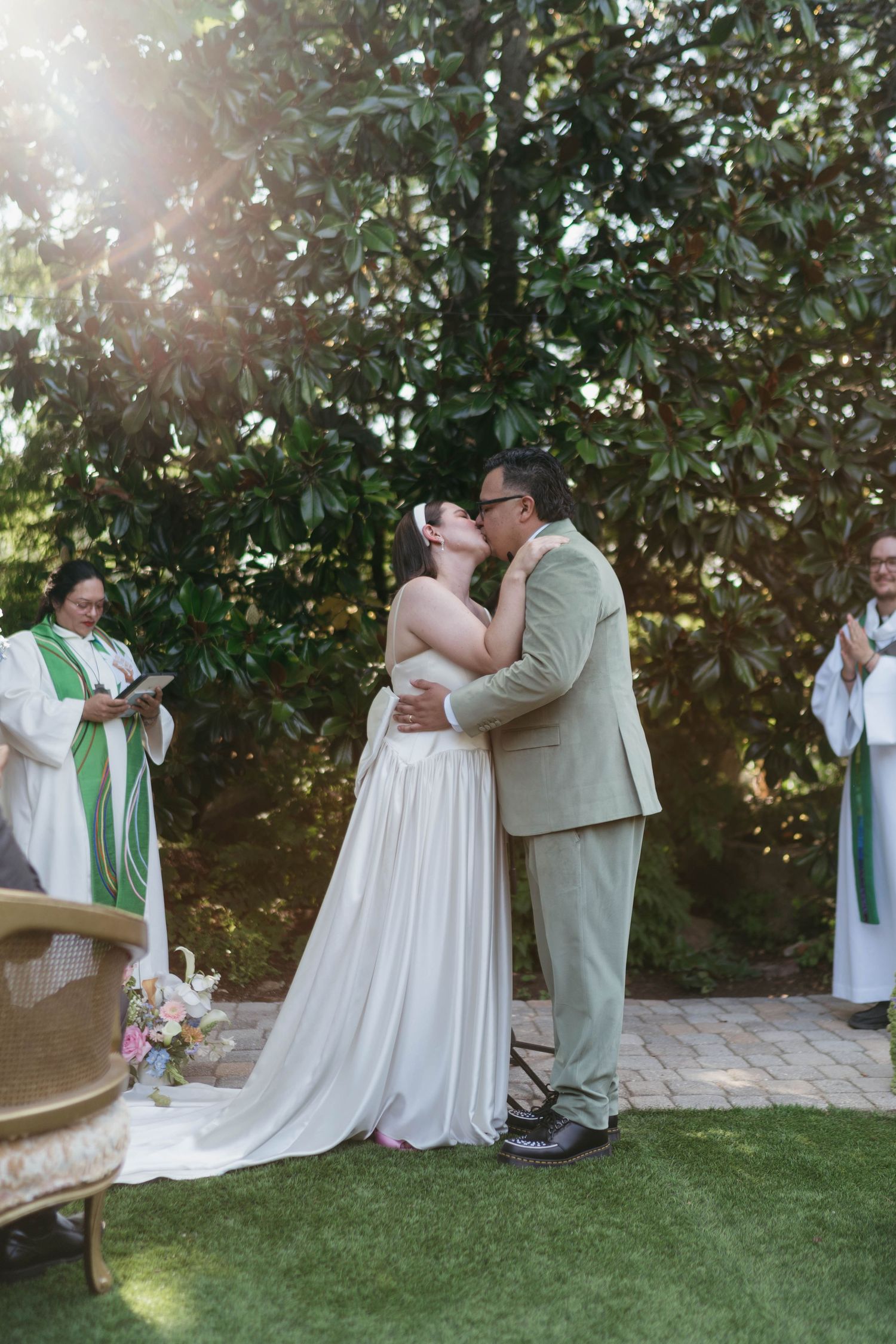 A couple shares an intimate first dance moment on a grassy lawn during their outdoor wedding celebration.