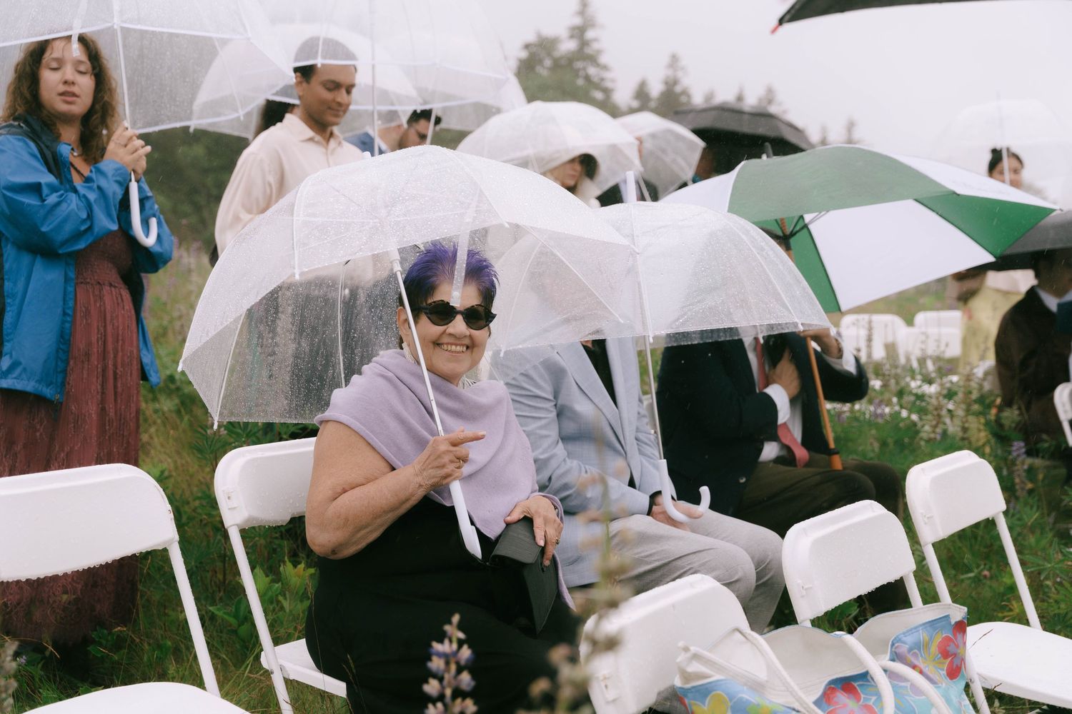 White umbrellas dot an outdoor gathering on an overcast day.