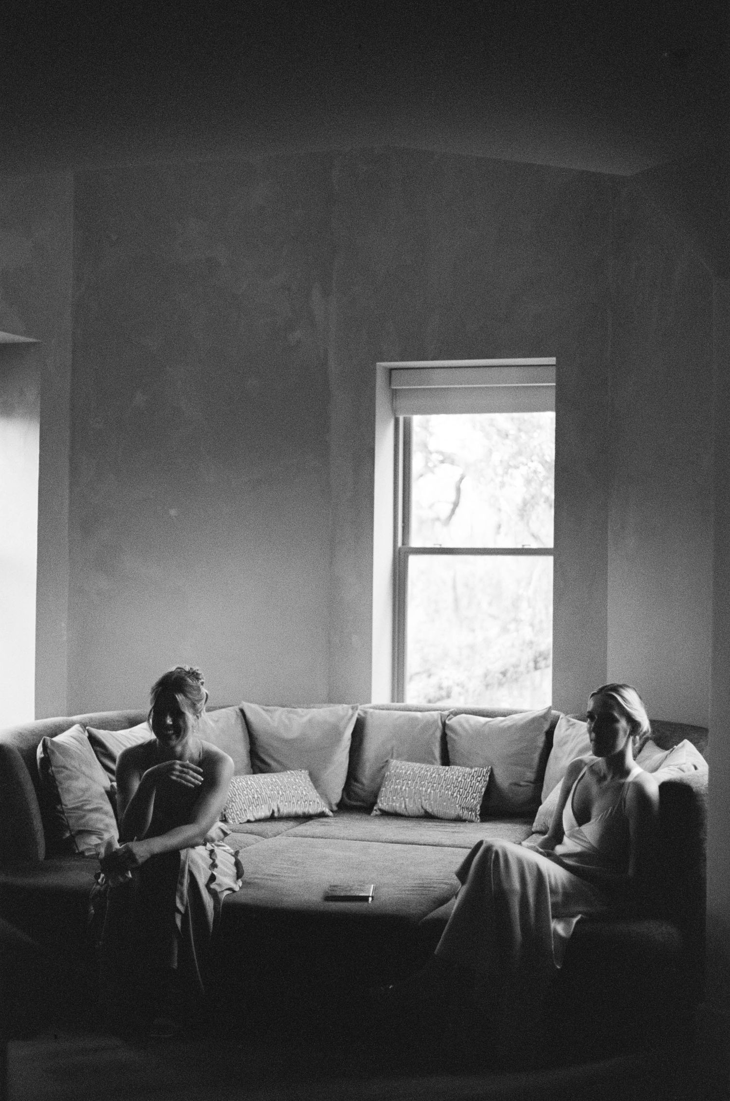 A series of dark atmospheric shots showing figures resting on a couch in dim lighting.
