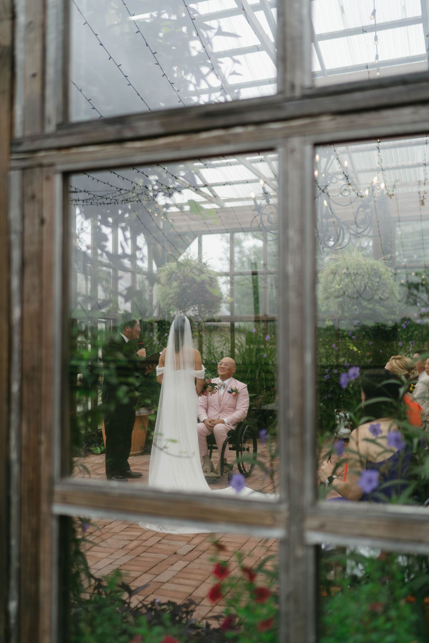 Interior view of a greenhouse with wedding decorations and floral arrangements.