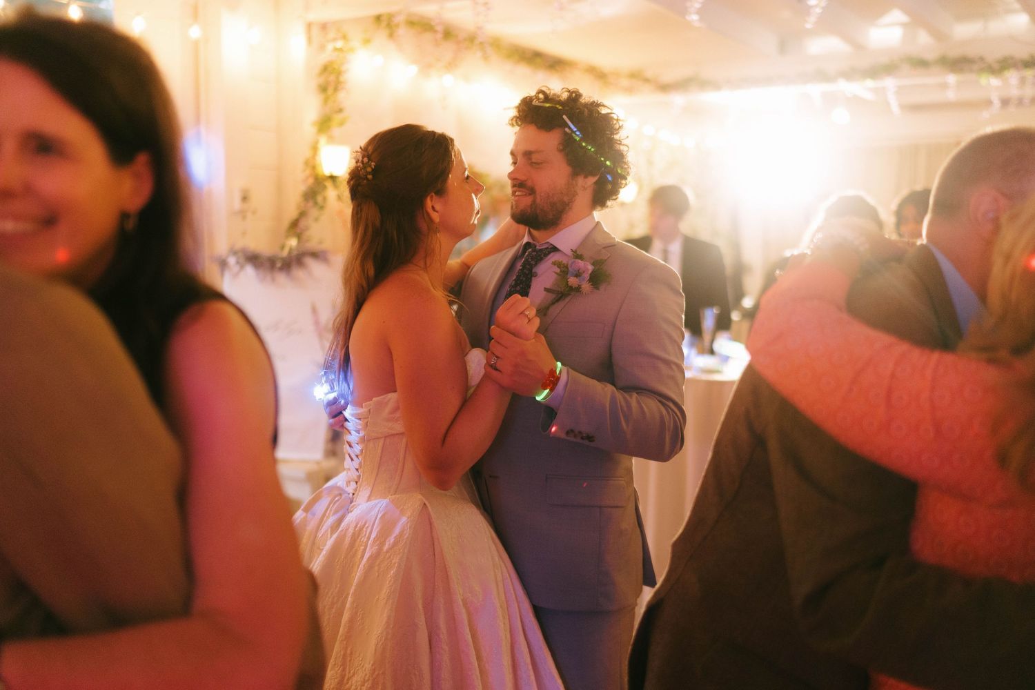 Wedding reception dance floor with warm ambient lighting and blurred motion.