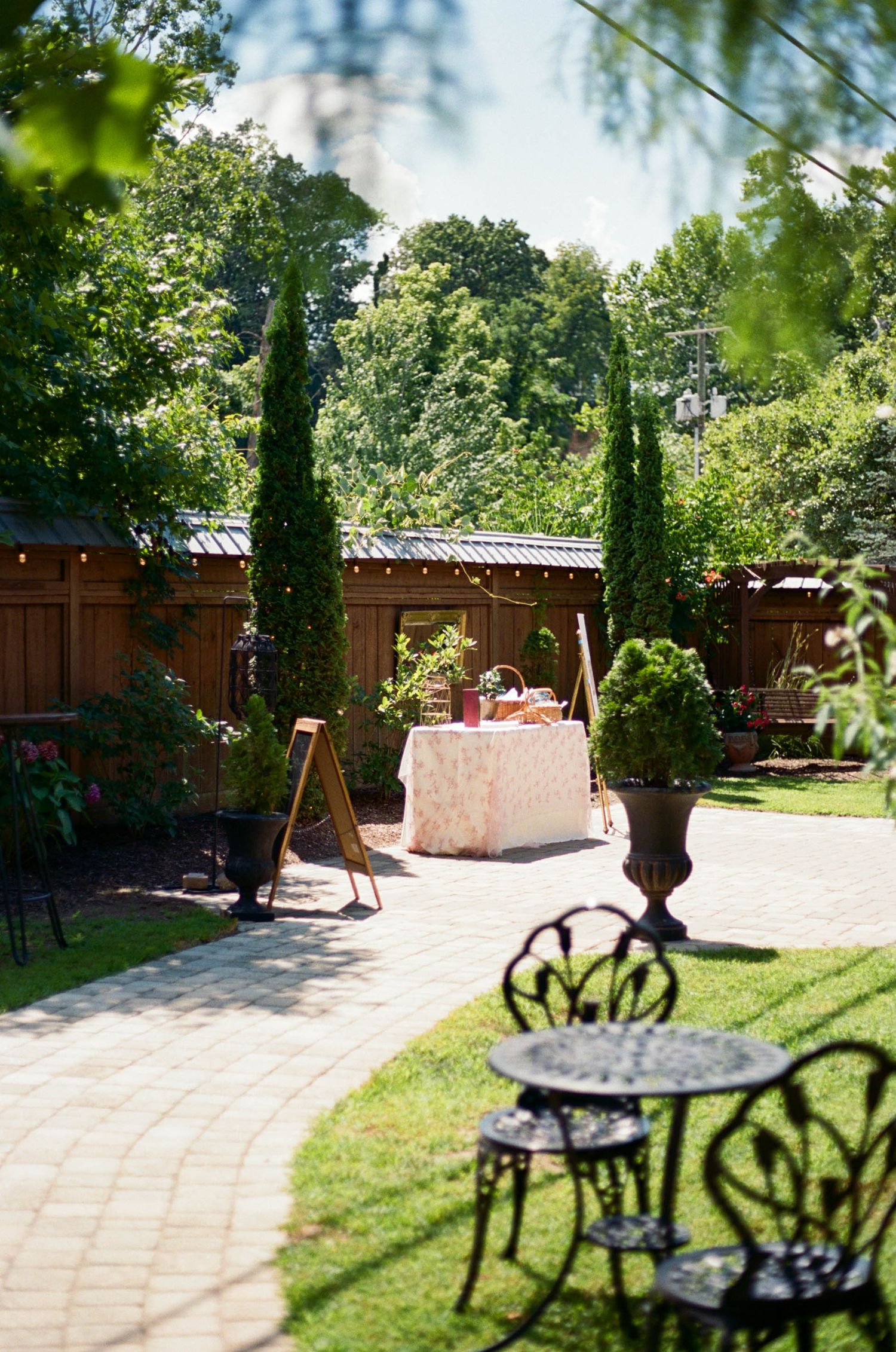 Garden wedding venue with curved brick pathway leading to covered patio area.