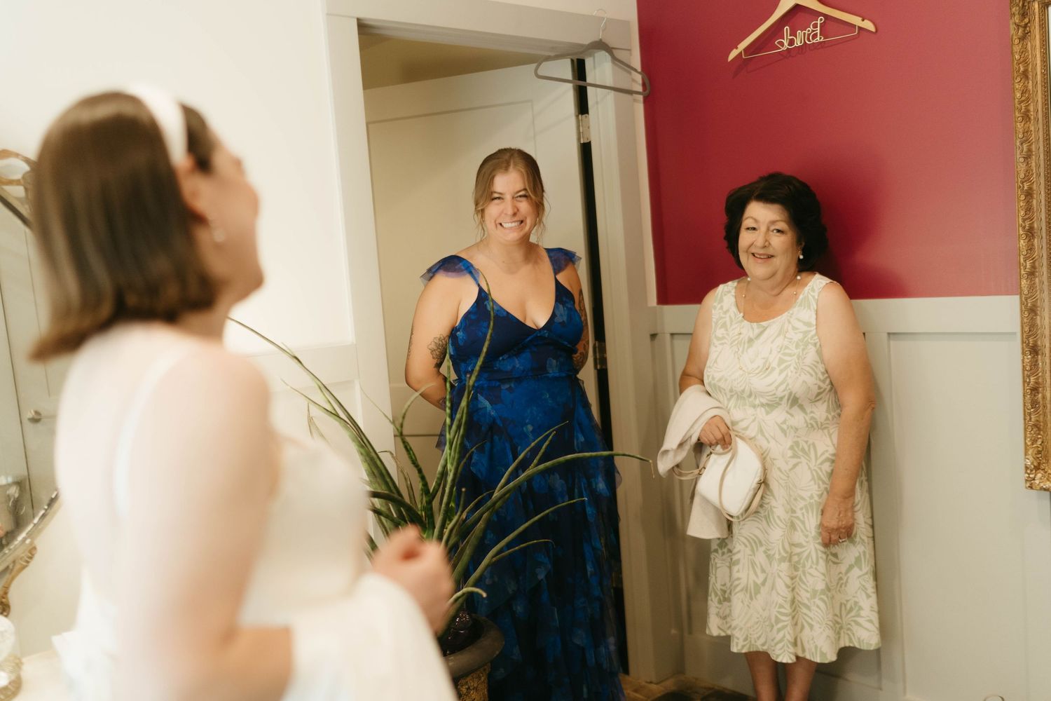 Wedding preparation room with dresses hanging on display and warm lighting.