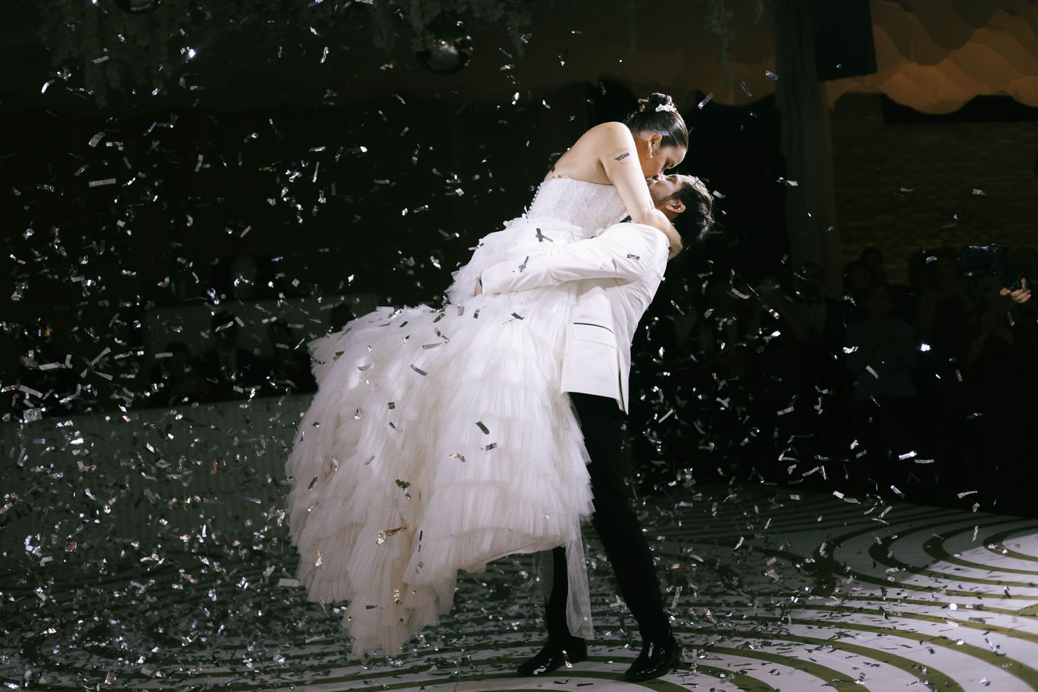 Wedding celebration with confetti falling against dark background creating magical atmosphere.