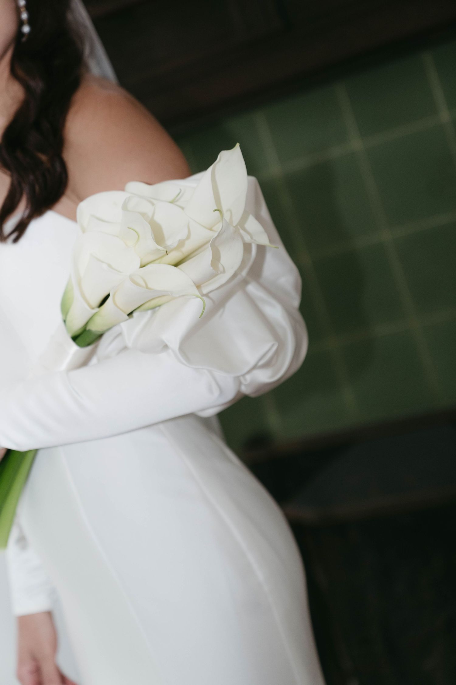 Close-up detail of a white wedding dress bodice with floral embellishments.