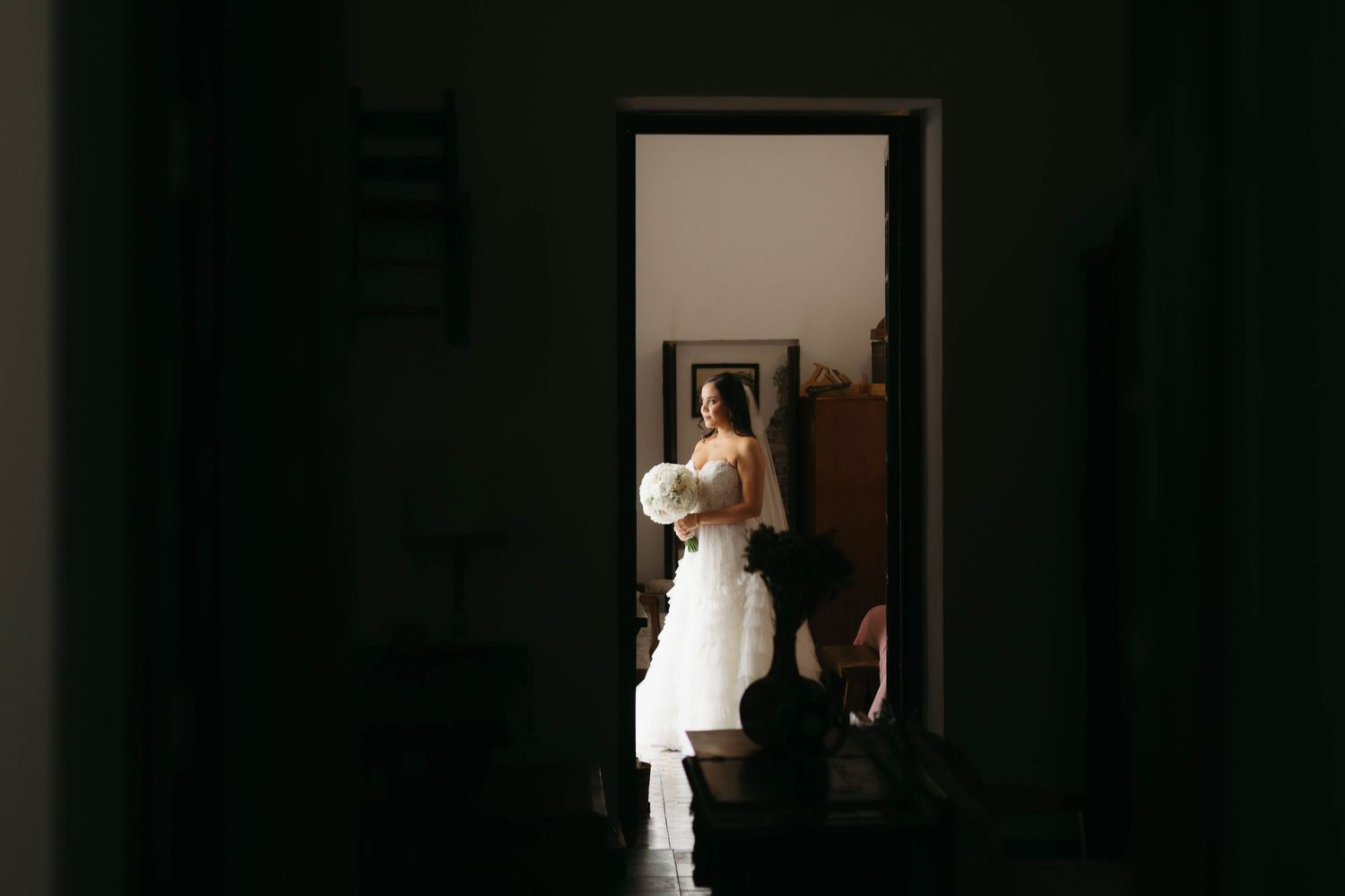 Dark hallway with white doorways and silhouettes creating dramatic contrast.