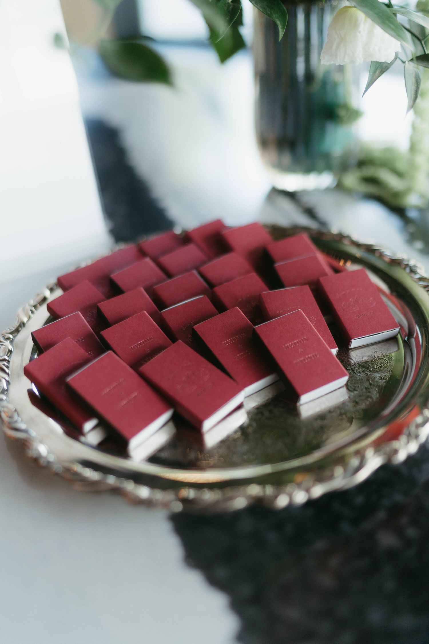 Red prayer books arranged neatly on a silver serving tray.