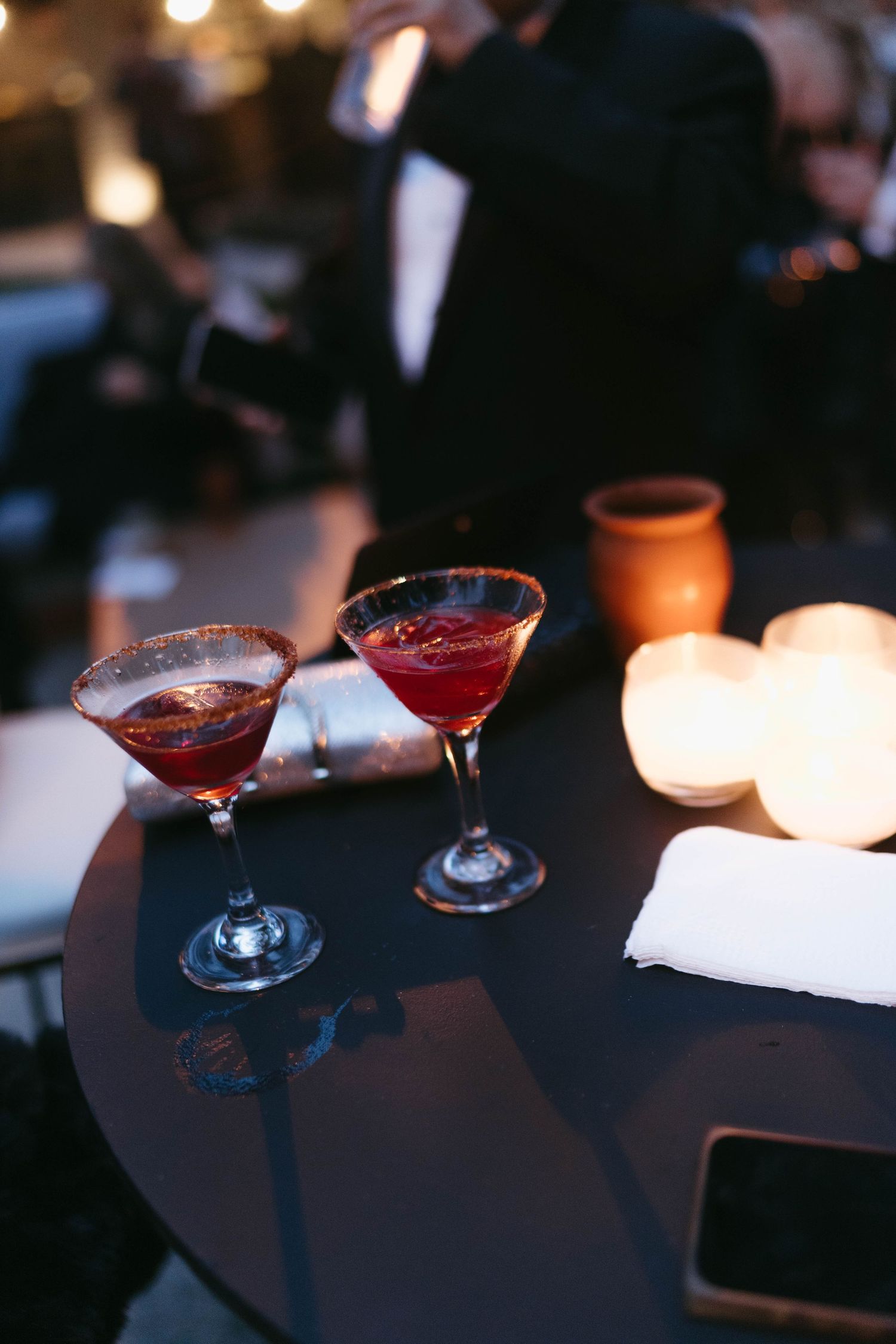 Cocktails on a dark table with ambient lighting at an evening event.