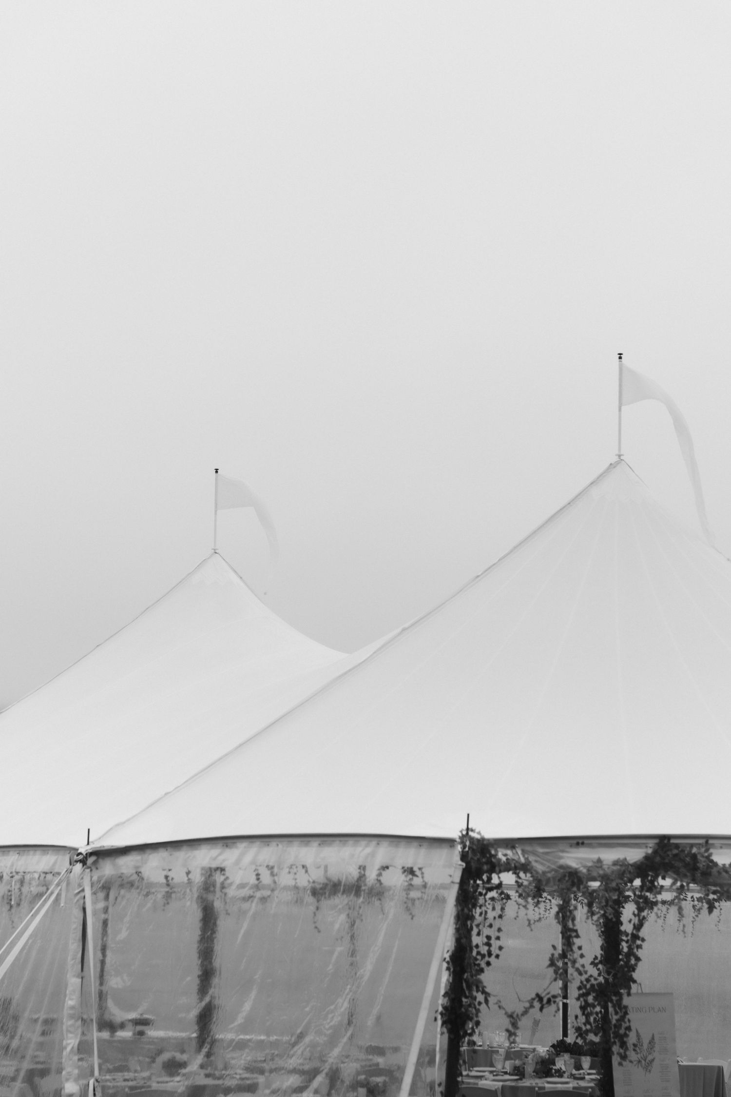White tent peaks rise against a misty grey sky.