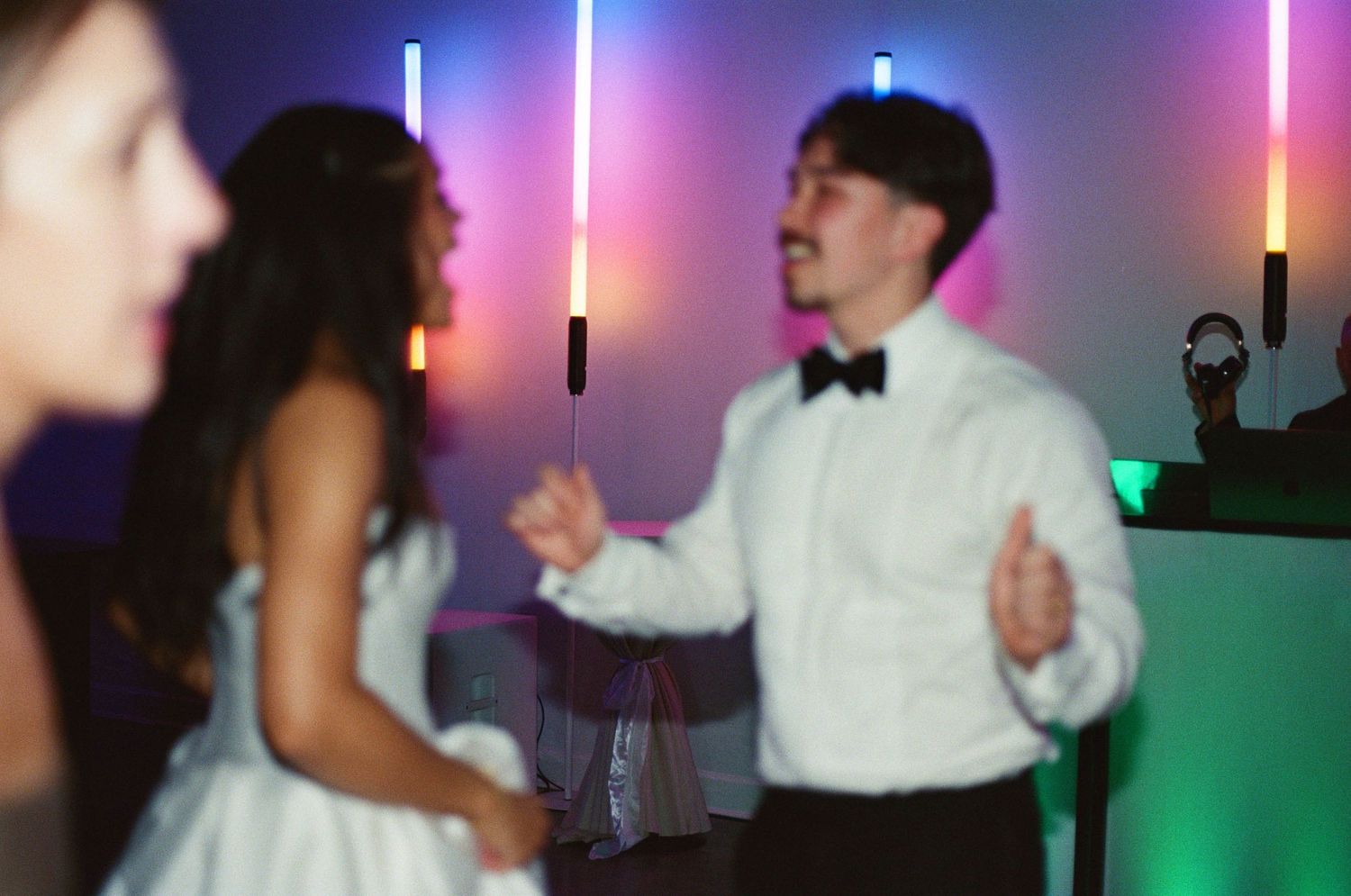 Wedding reception dance floor illuminated with colorful lights and glowsticks.