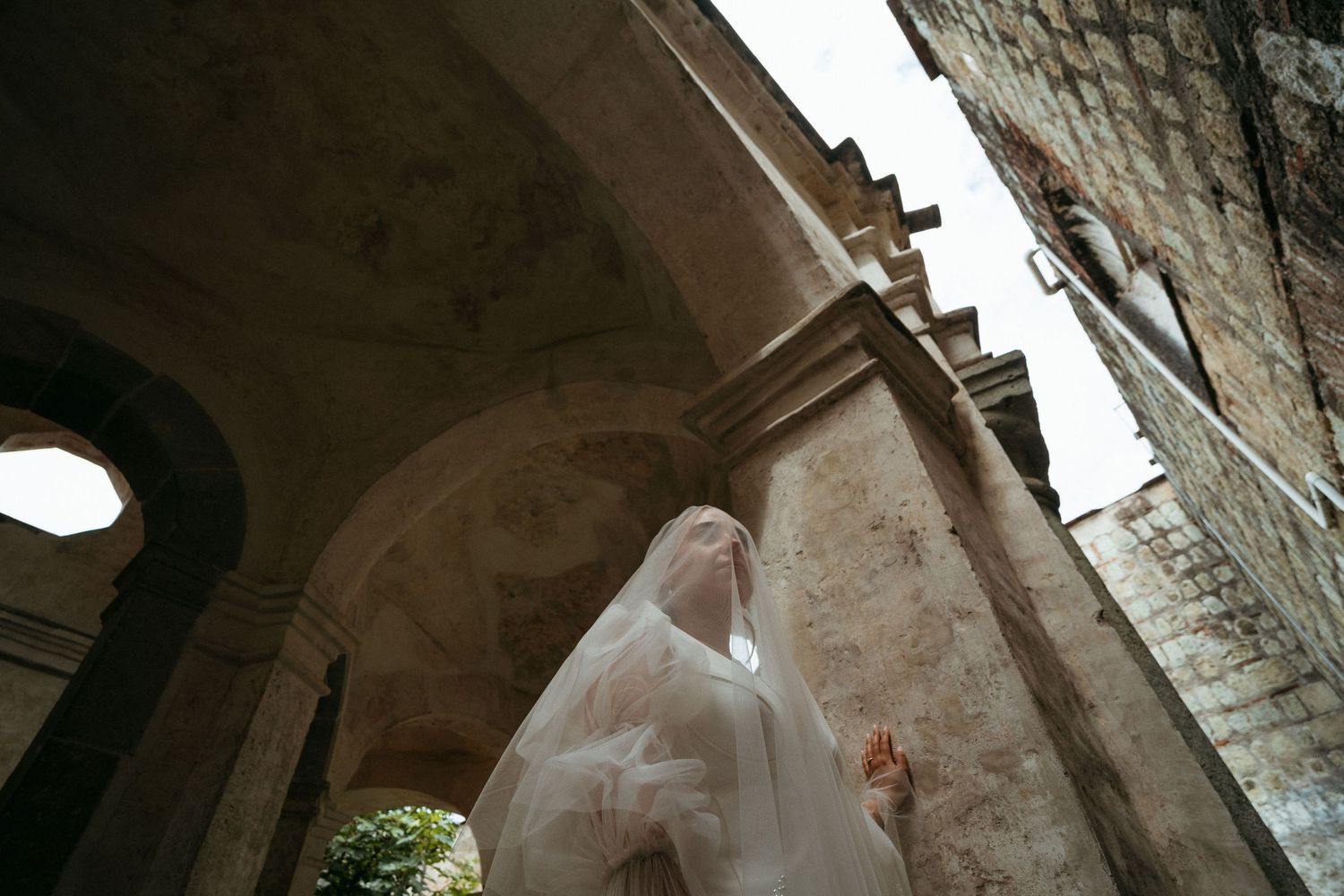 Stone archways and walls create dramatic shadows in an ancient architectural setting.