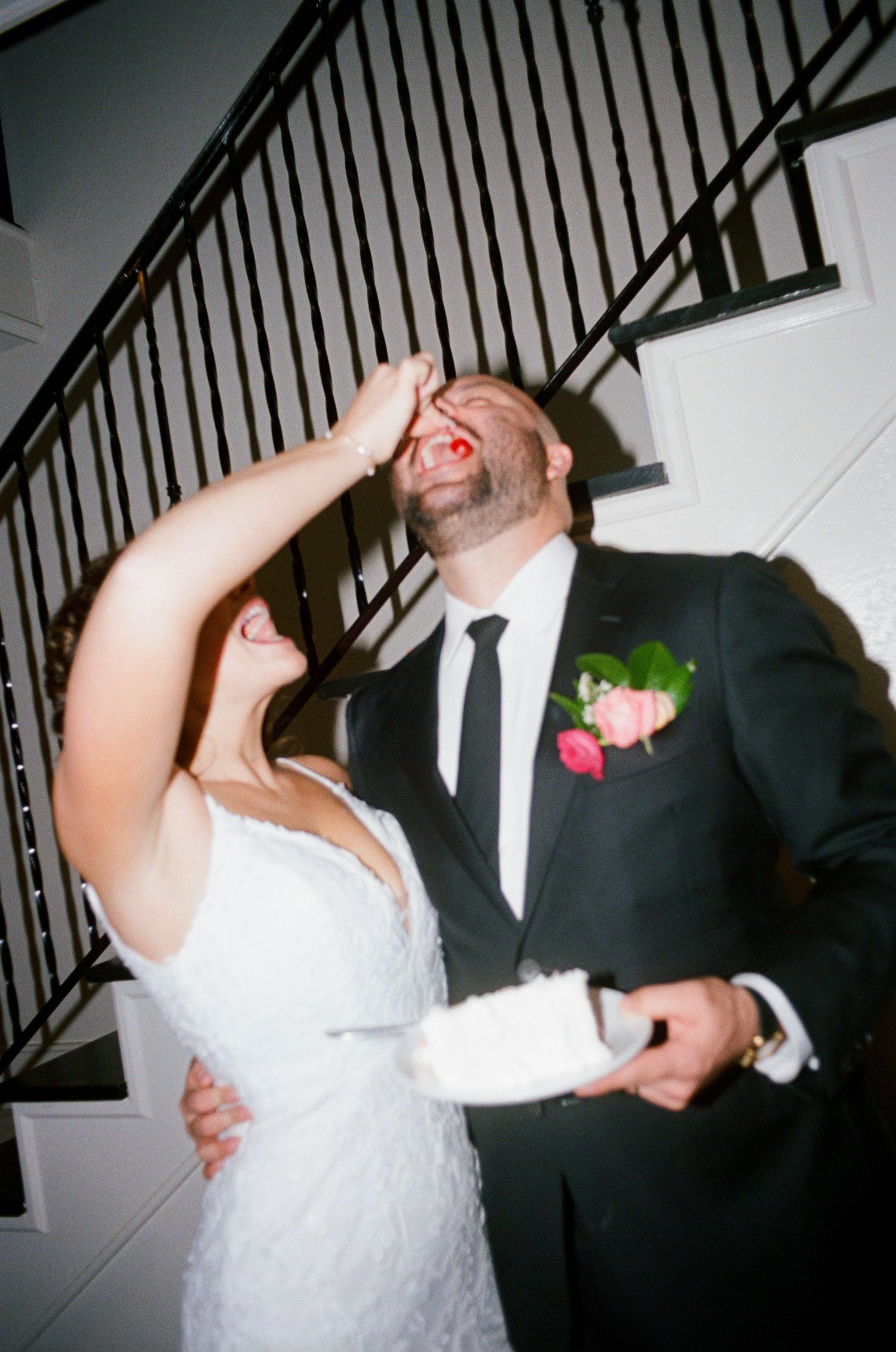 Fun dancing moments captured between couple near indoor staircase.