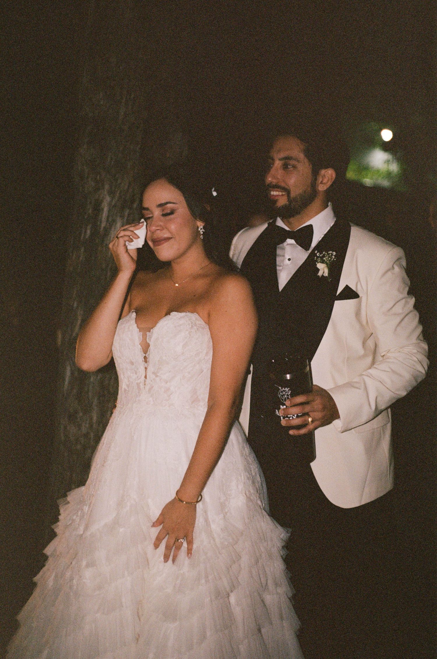 An emotional wedding moment captured during an evening celebration.