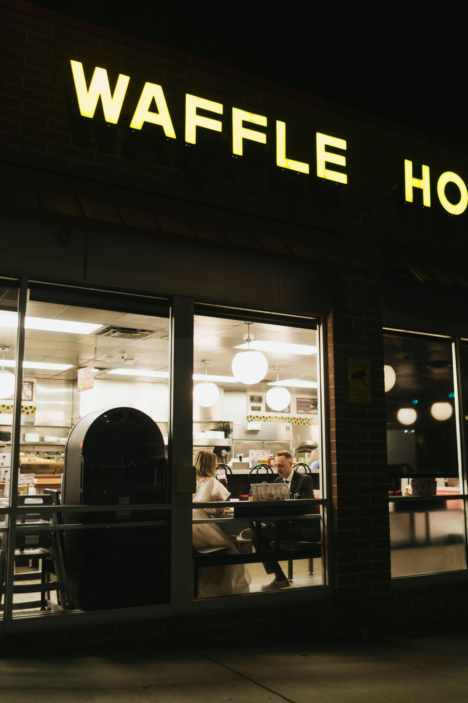 Illuminated Waffle House storefront at night with glowing signage and windows.