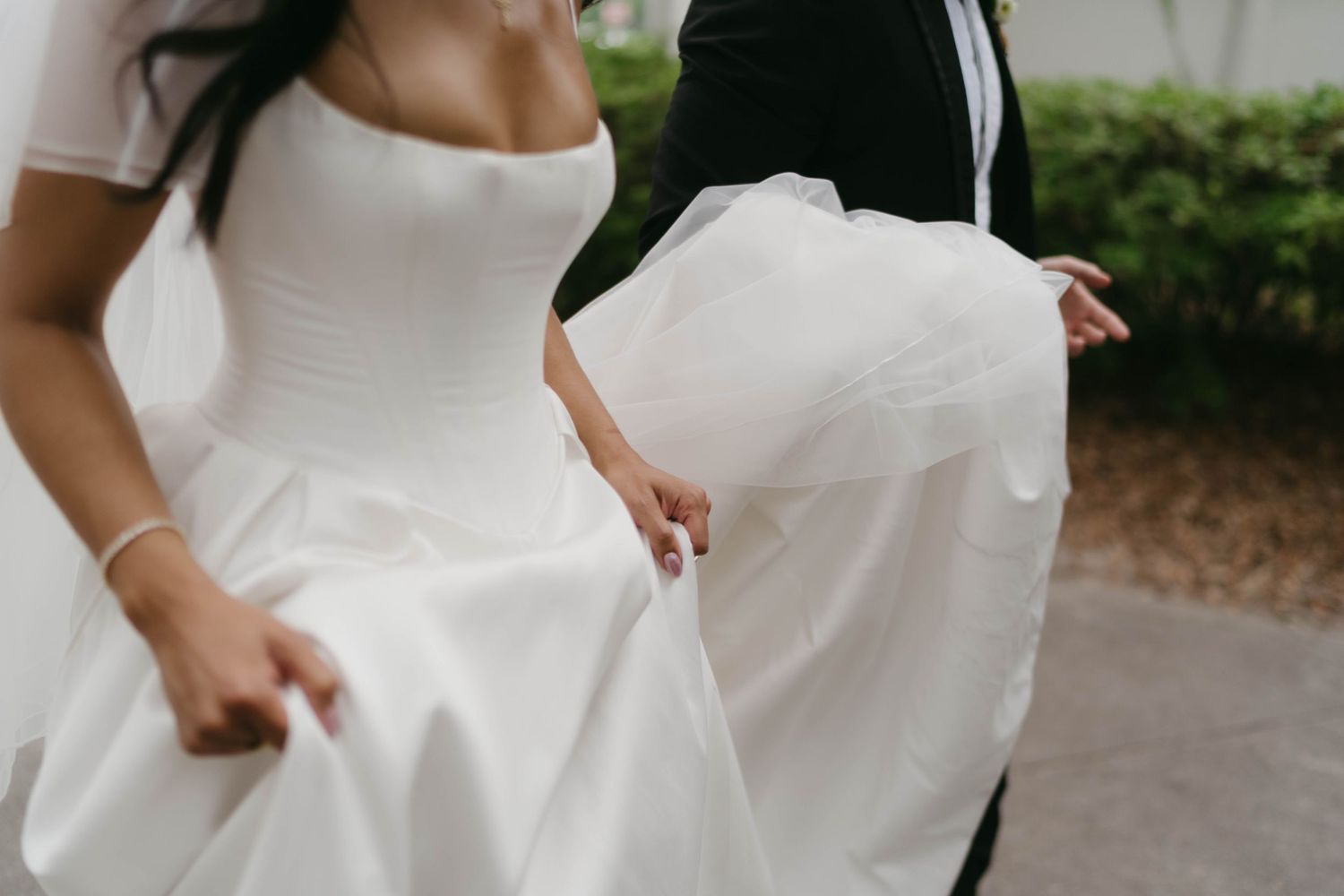 Close-up details of white wedding dresses flowing in motion.
