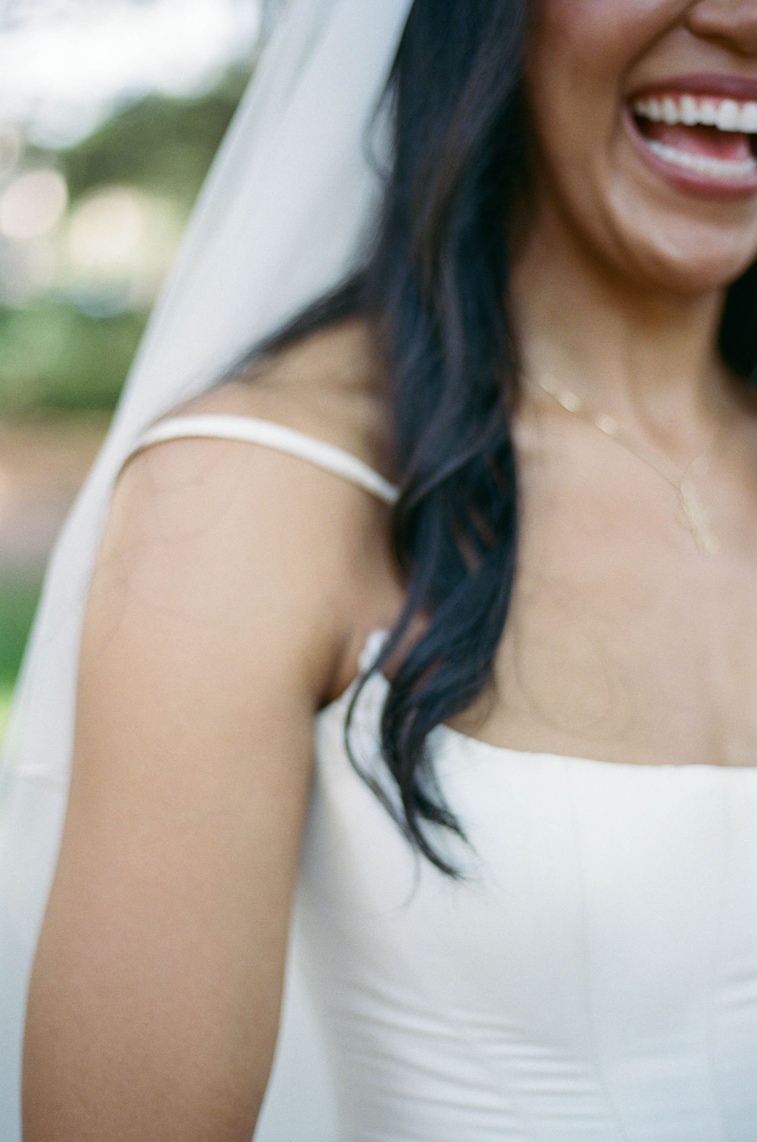 Close-up details of a bride's white wedding dress and veil.