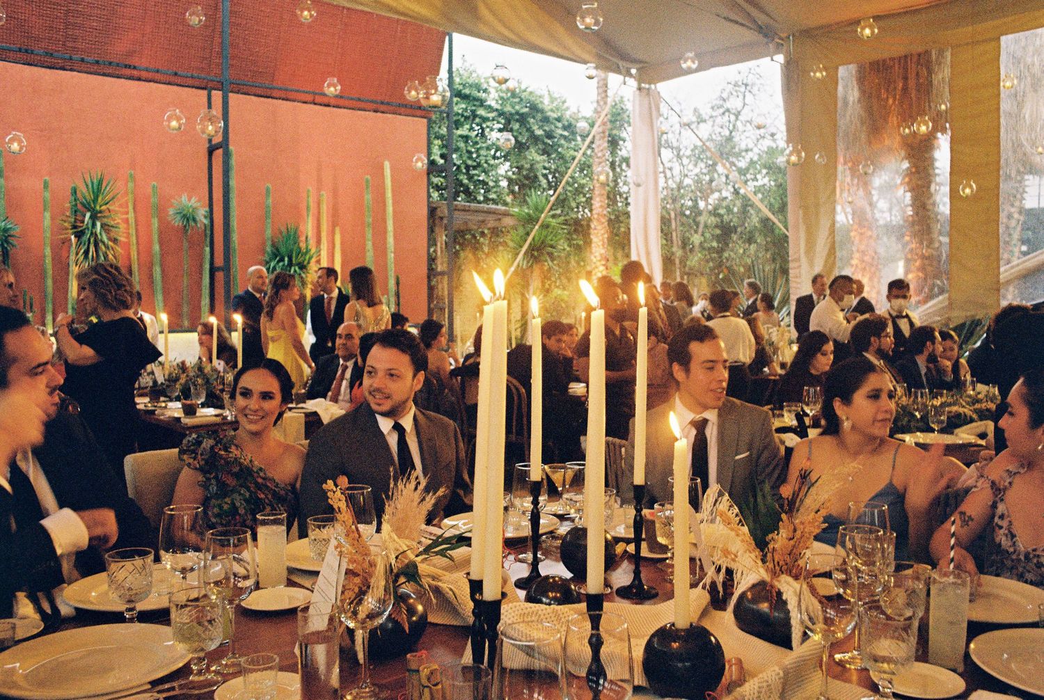 Wedding reception venue with warm lighting and guests gathered at tables.