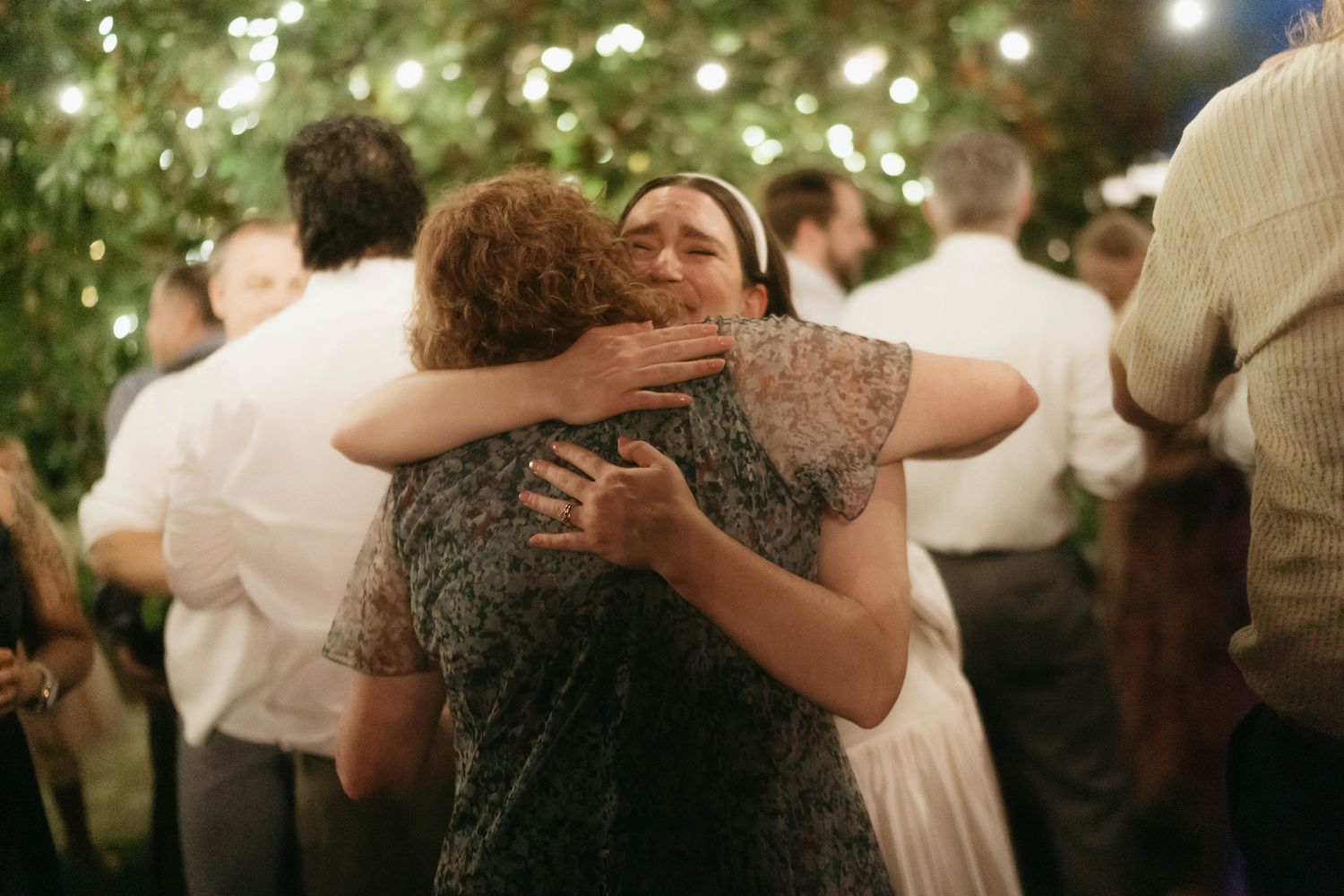 Dancing couples embrace on an outdoor dance floor during an evening celebration.