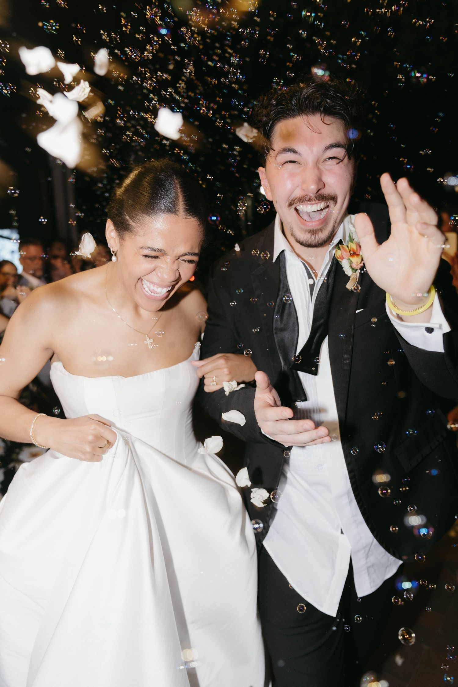 Newlyweds celebrate with bubbles and laughter during wedding reception.