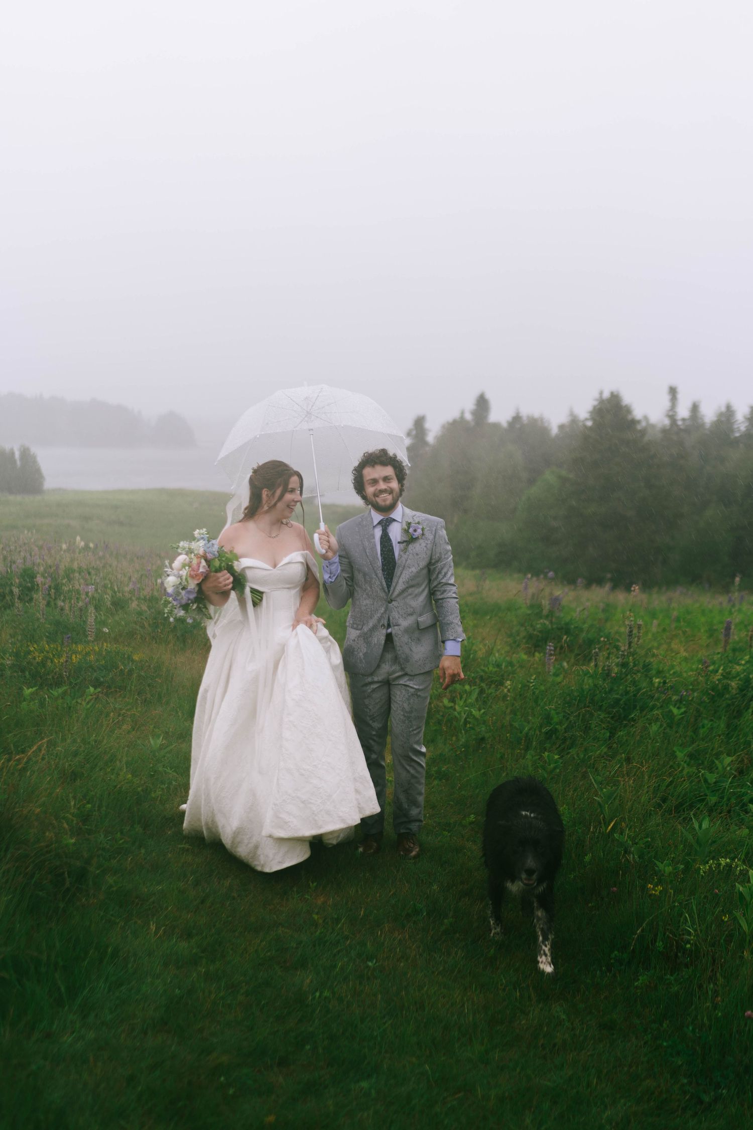 Wedding couple walking through a misty field on an overcast day.