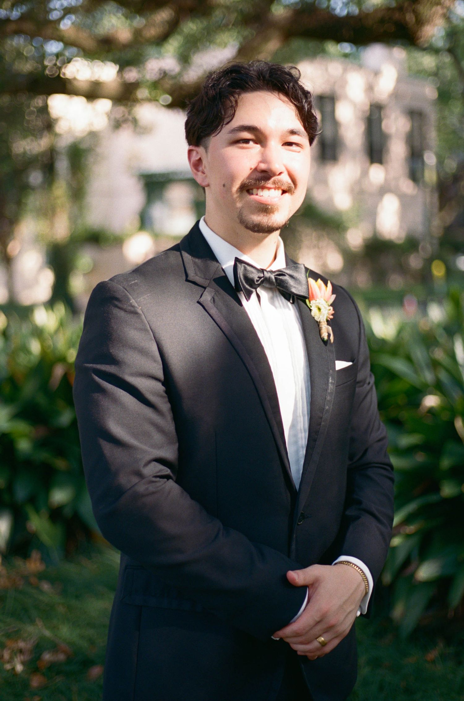 Formal wedding attire details showing black tuxedo with bow tie.