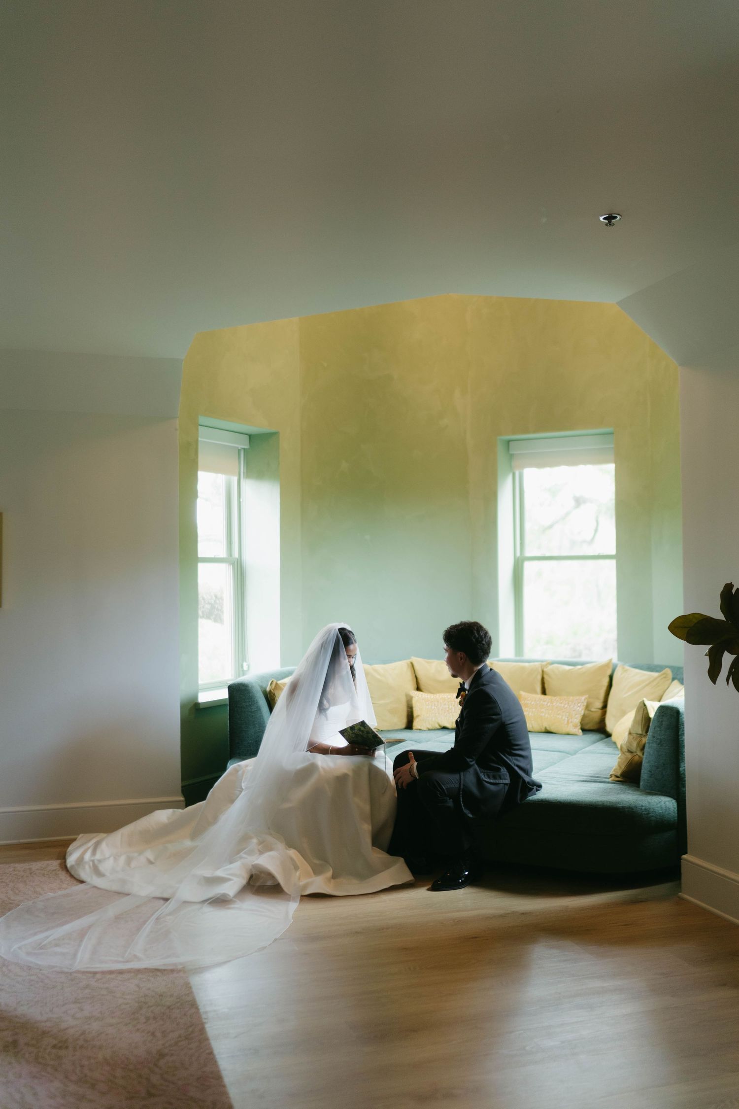 A bright room with yellow walls and windows showing wedding preparations.