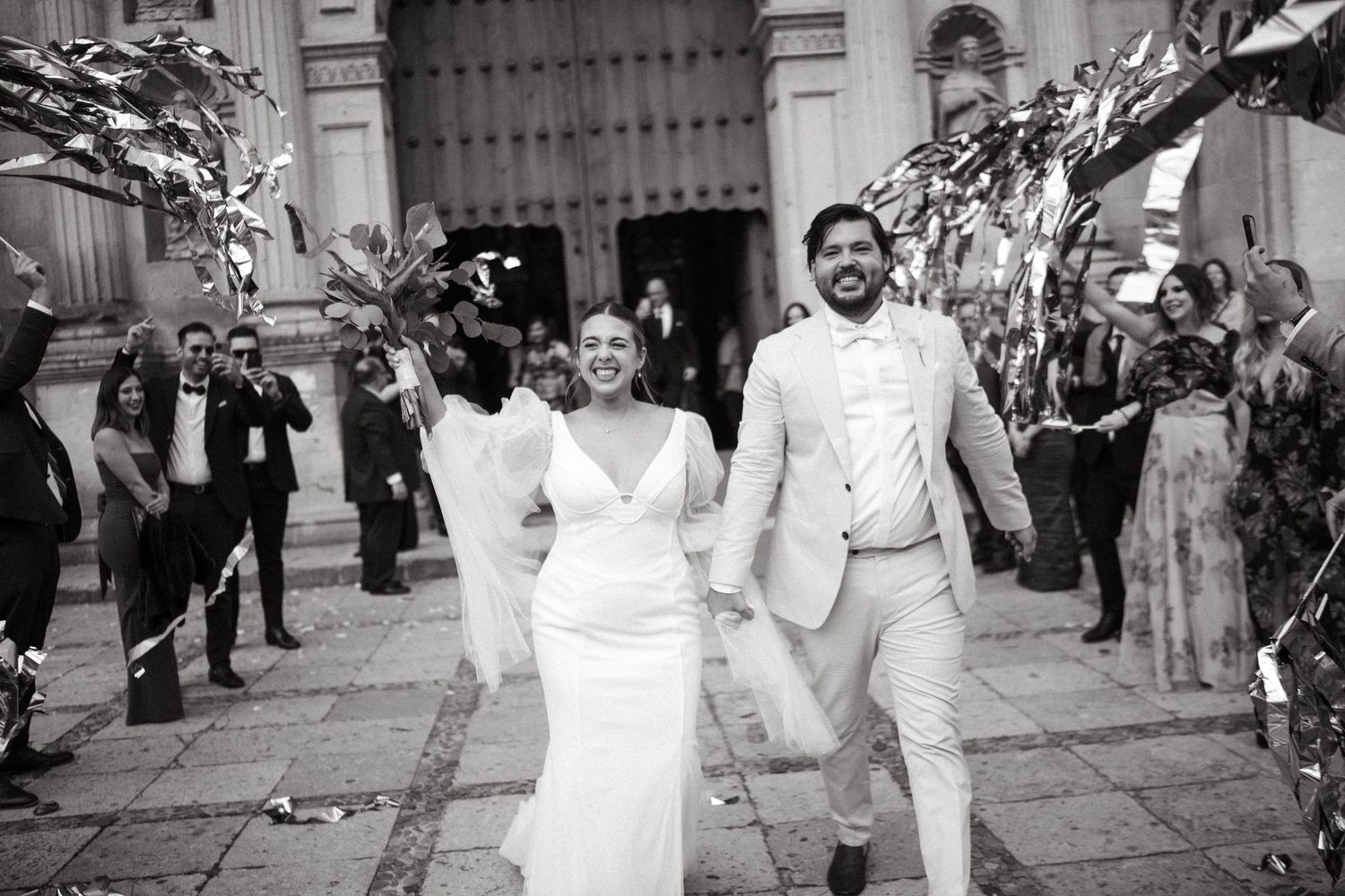 Black and white photo series of a wedding couple dancing and celebrating outside a grand church entrance.