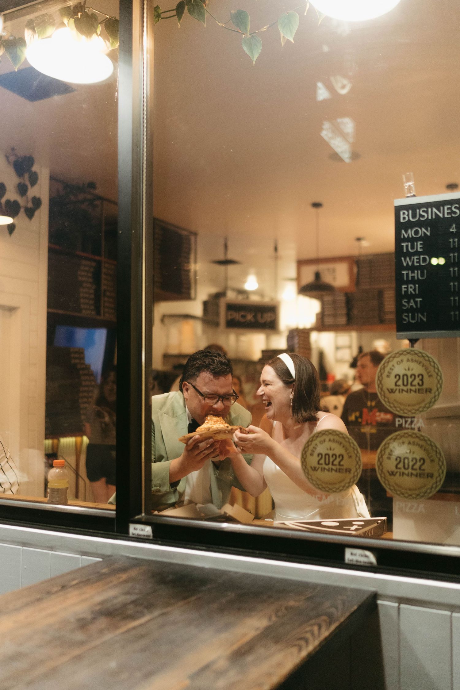 Restaurant window scene with award plaques displayed and wooden counter in warm lighting.